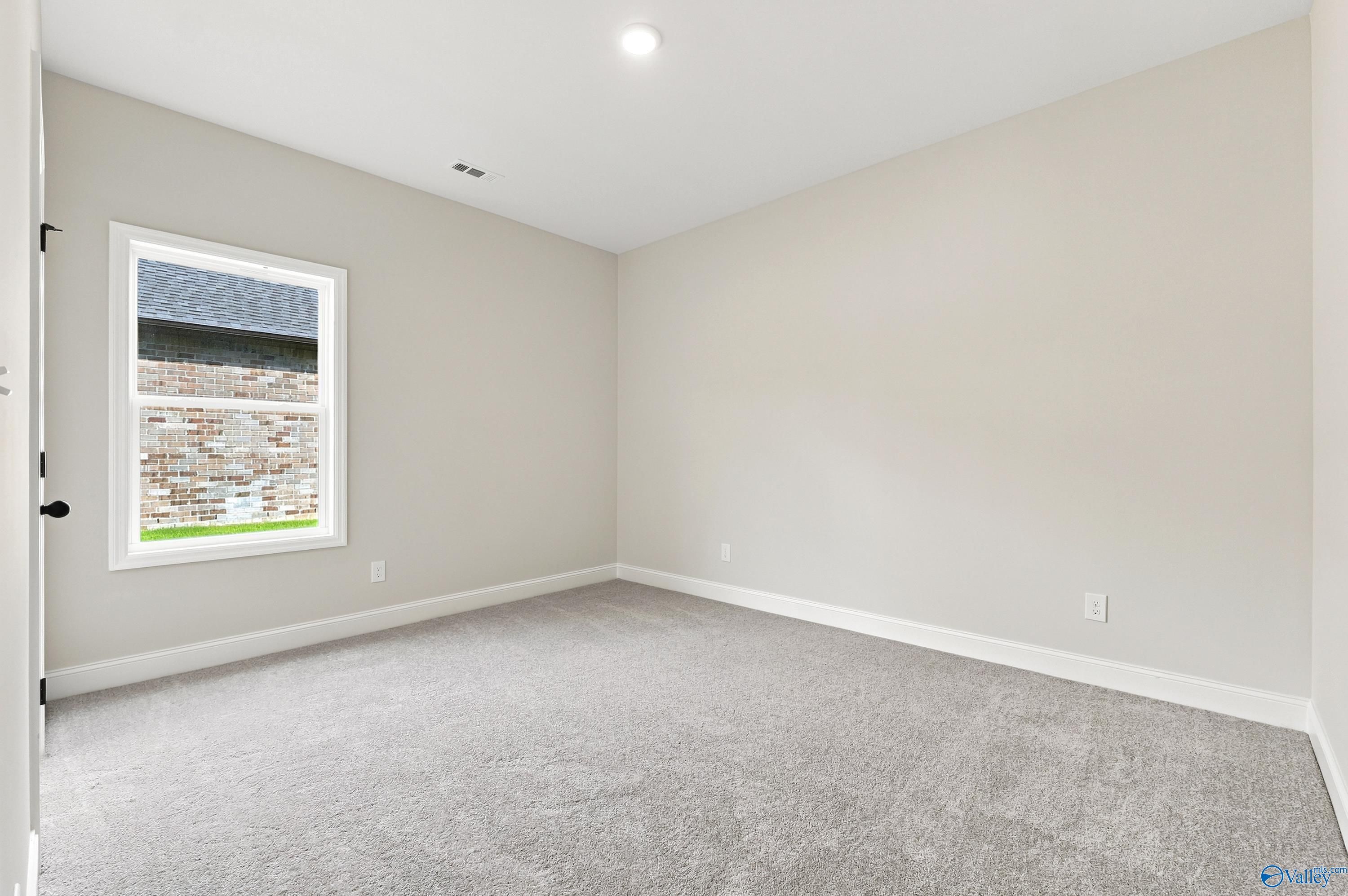 Bright, neutral-toned bedroom with plush carpet in The Daphne floor plan by Davidson Homes in Lynn Meadows, Meridianville.