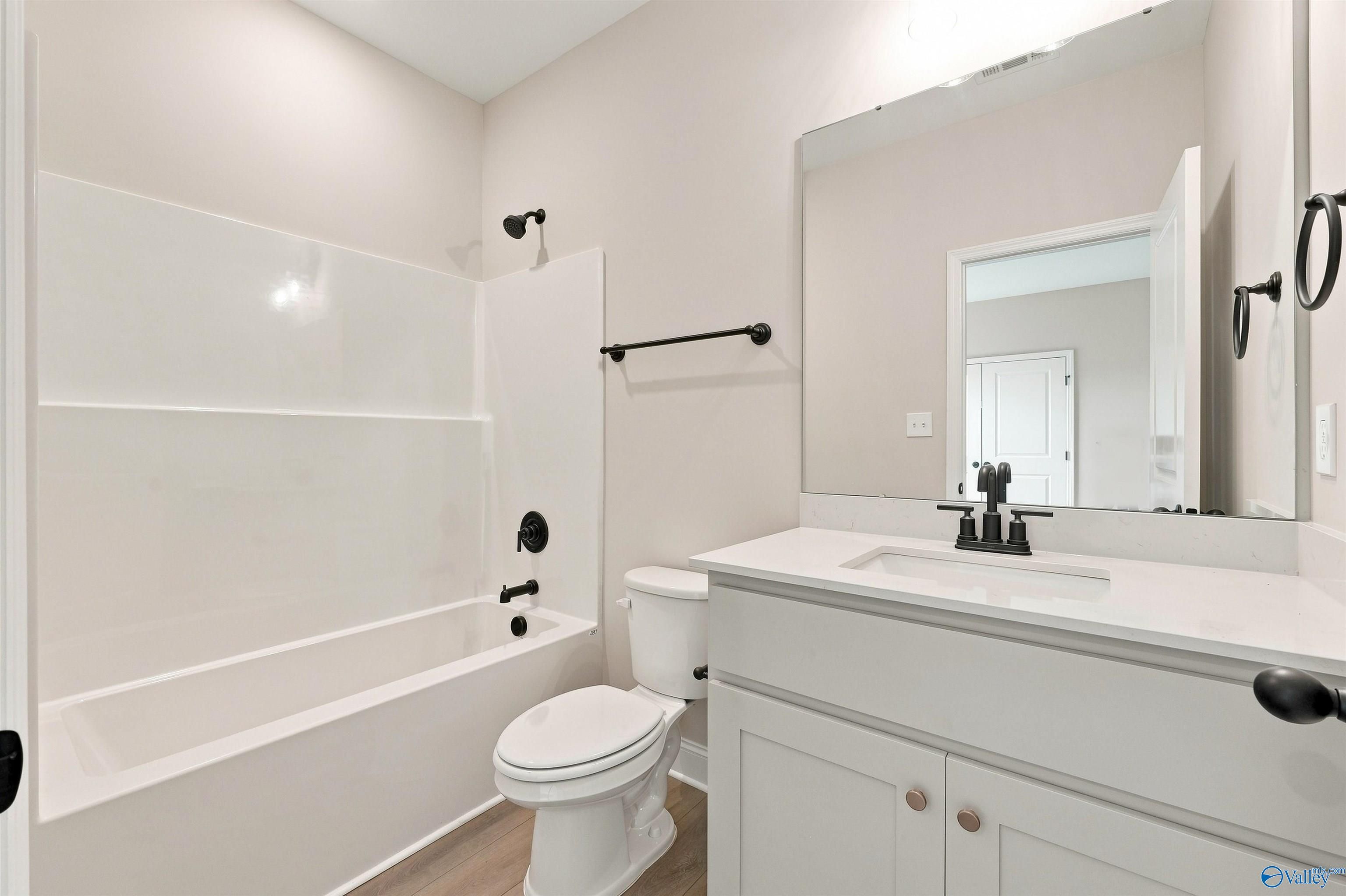 Modern bathroom with white vanity, quartz countertop, and matte black fixtures in The Oxford floor plan, Kendall Farms.