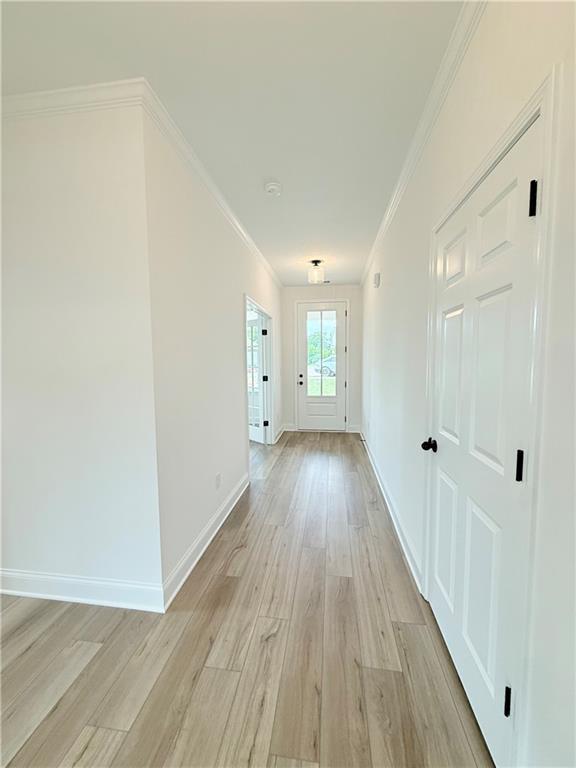 Bright hallway with light wood-style flooring and white interior doors in The Hickory B floor plan at Wehunt Meadows.