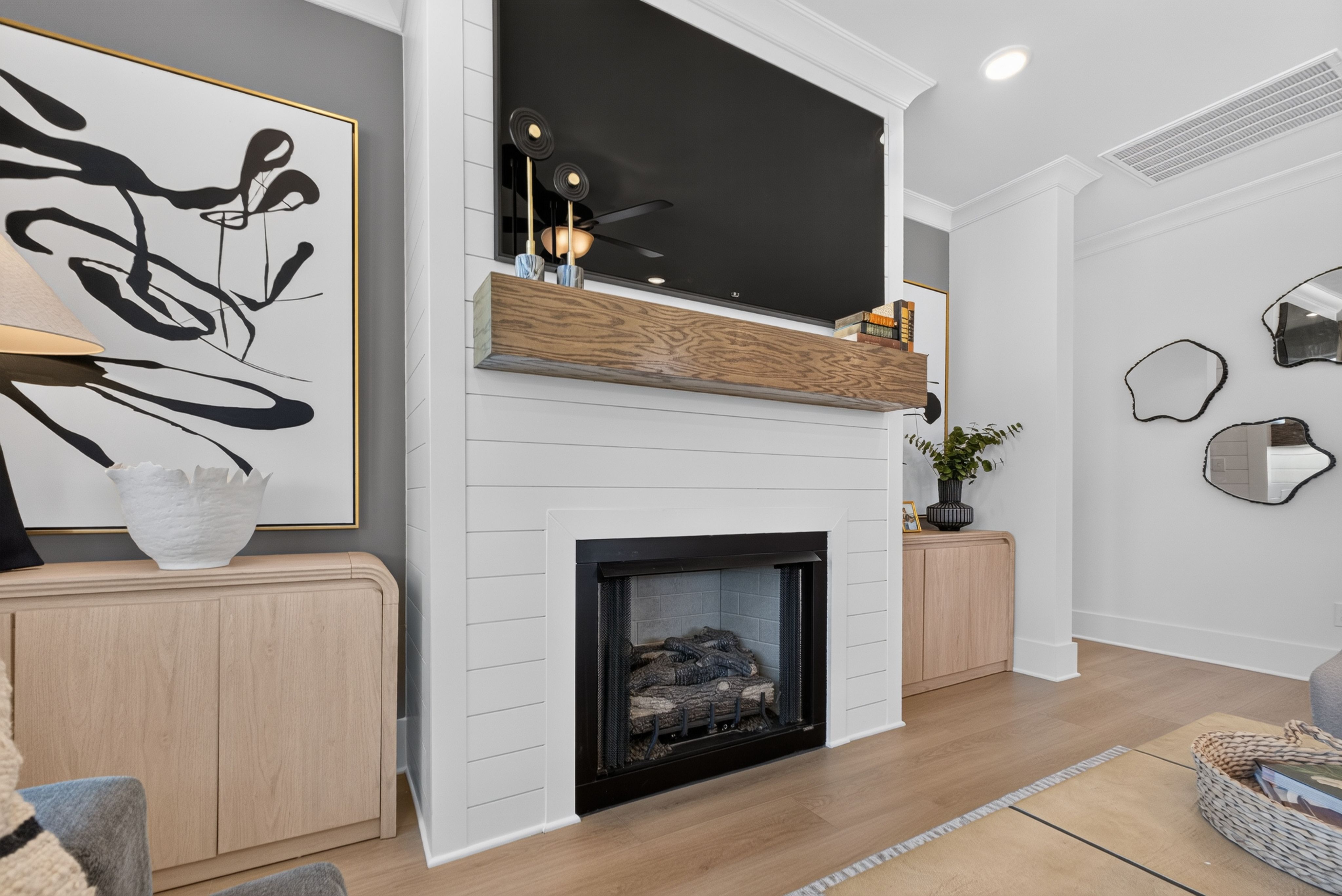 Living room with shiplap fireplace, wood mantel, and mounted TV at Evergreen Mill by Davidson Homes in Madison, Alabama