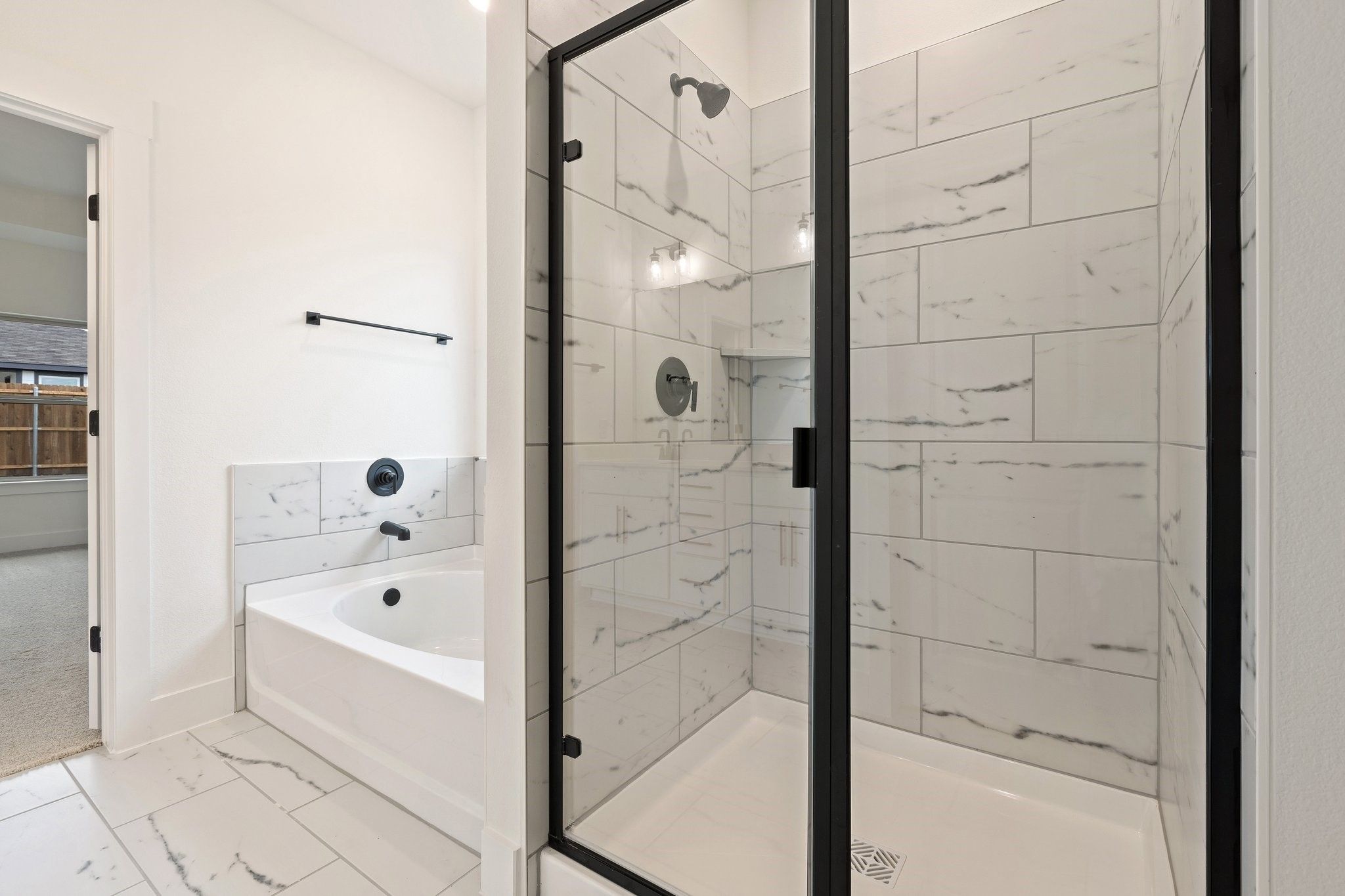Modern primary bathroom with walk-in shower and soaking tub in The Rockford C floor plan at Waverly Estates, Josephine, TX.
