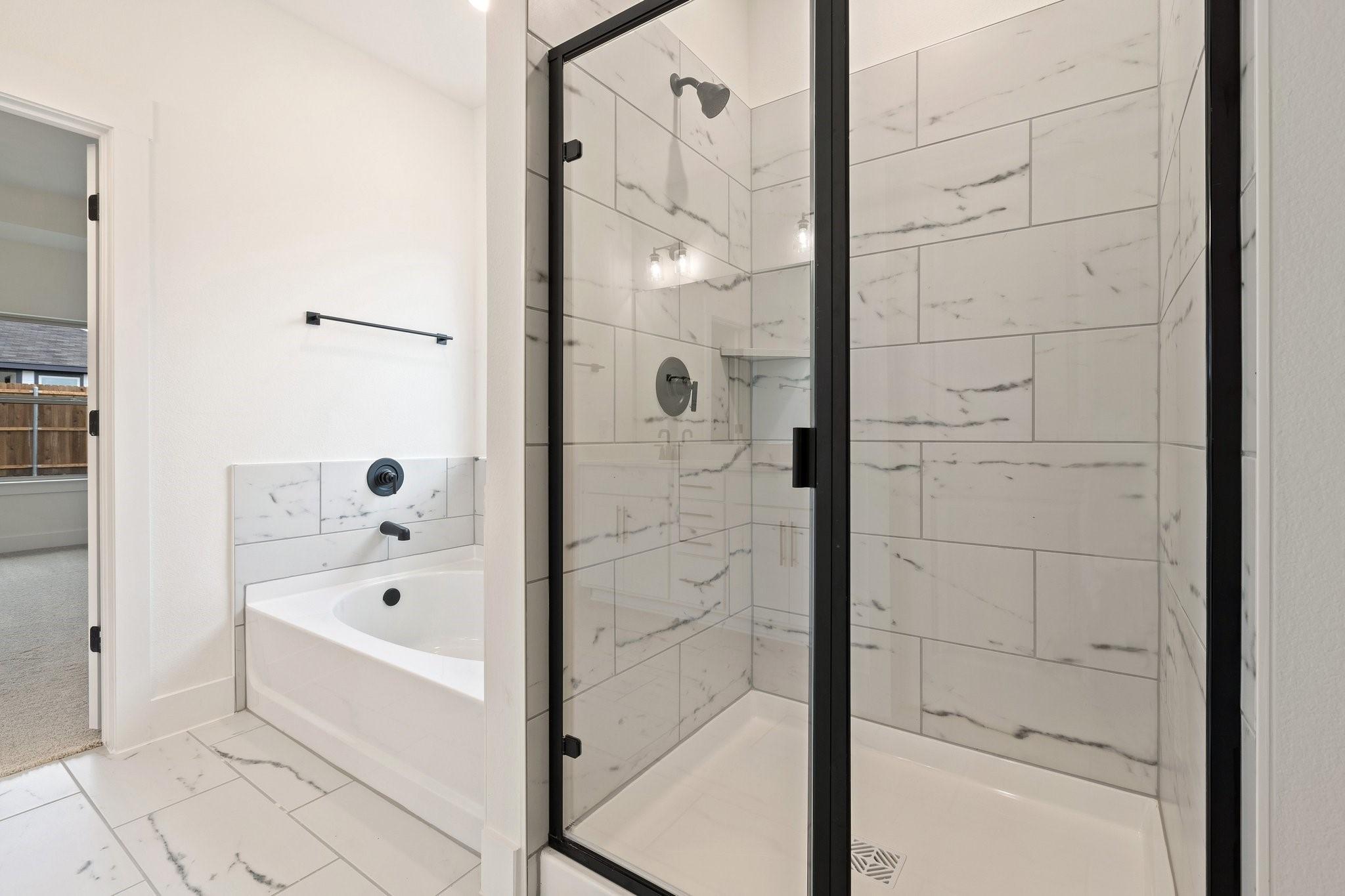 Modern primary bathroom with walk-in shower and soaking tub in The Rockford C floor plan at Waverly Estates, Josephine, TX.