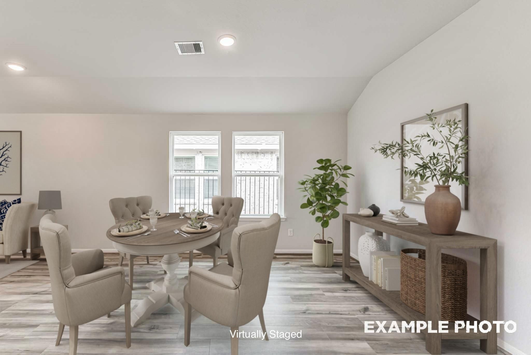 Bright dining room with wood-look flooring in The Laguna C floor plan by Davidson Homes in Sunterra, Katy, Texas.