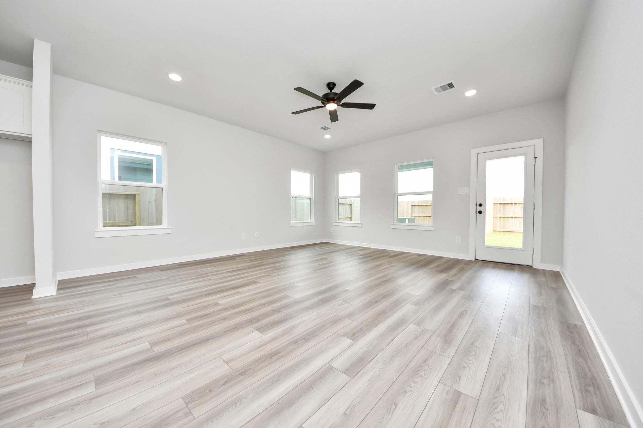 Spacious, light-filled living area with wood-look flooring and ceiling fan in The Sorrento E floor plan, Sundance Cove.
