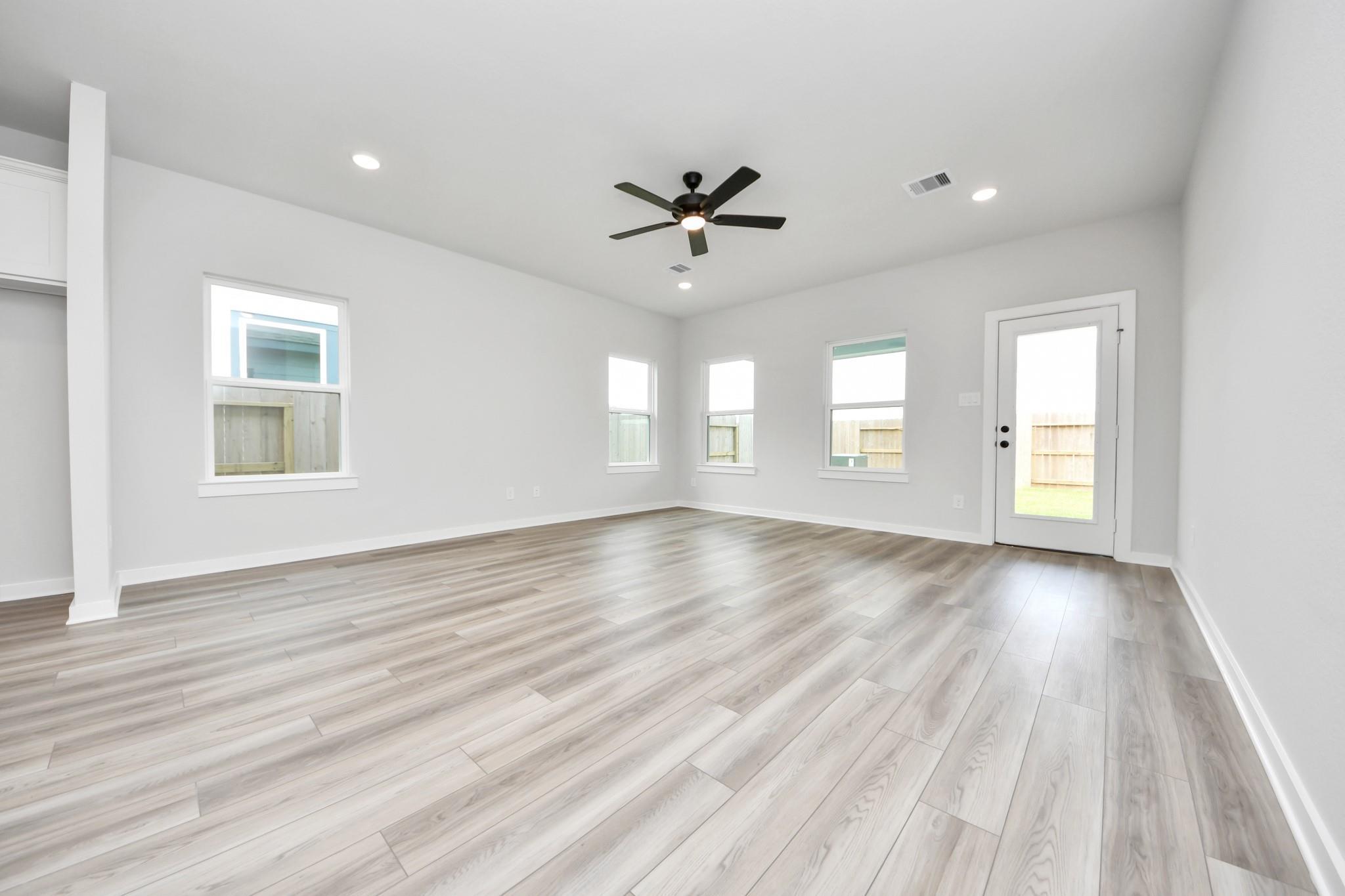 Spacious, light-filled living area with wood-look flooring and ceiling fan in The Sorrento E floor plan, Sundance Cove.