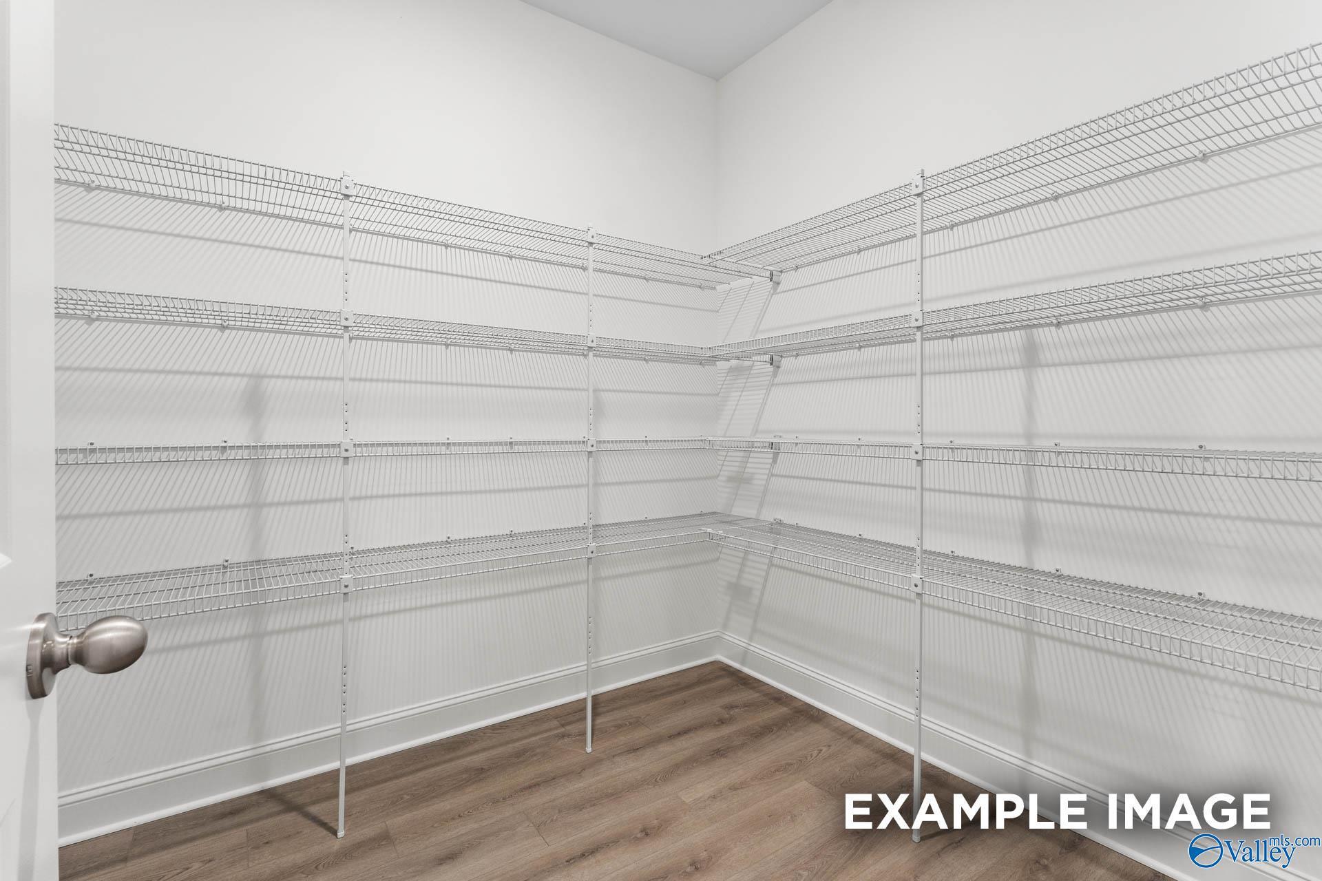 Spacious walk-in closet with white wire shelving in corner, hardwood floors in The Finleigh by Davidson Homes, Huntsville