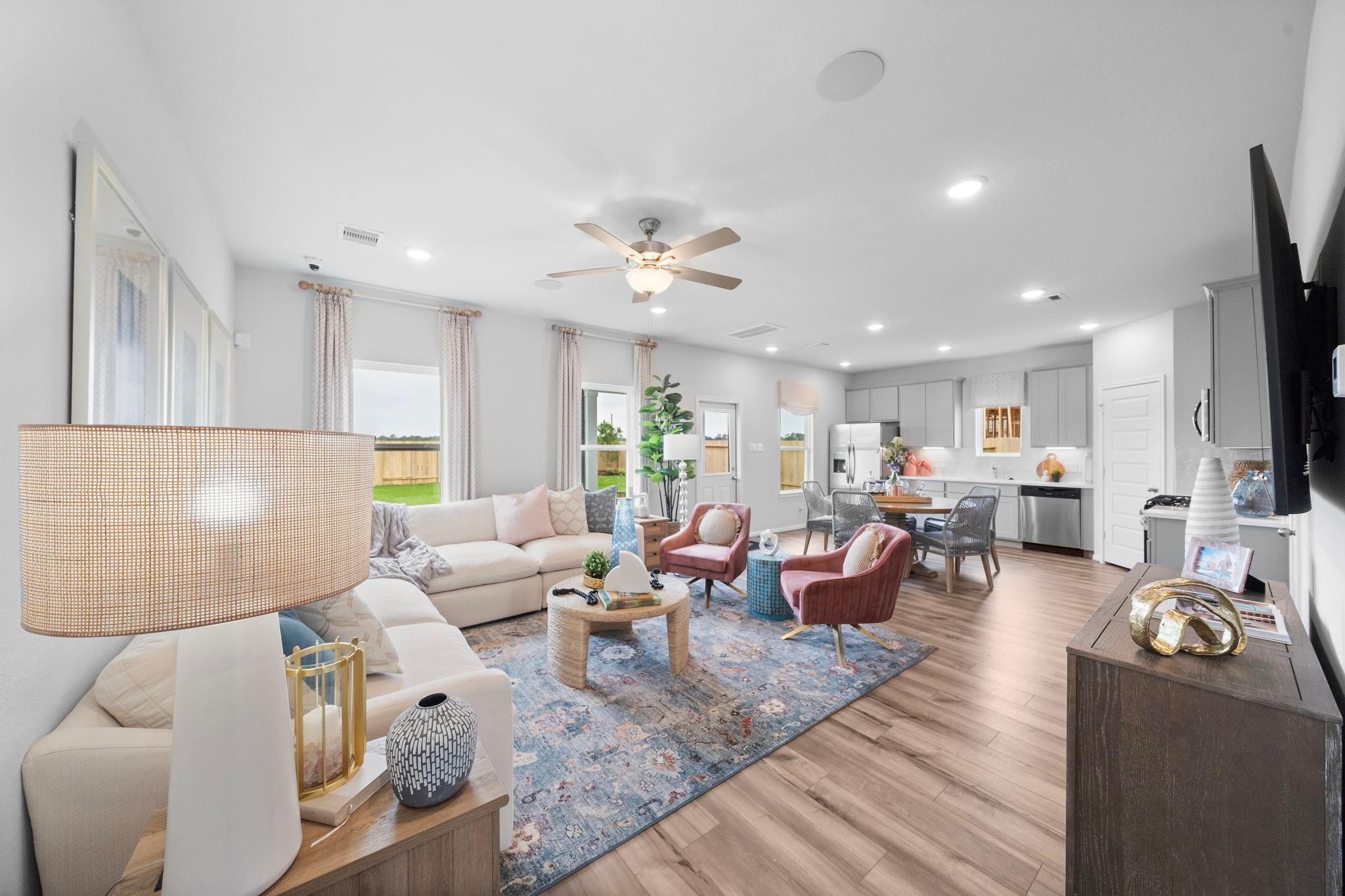 Spacious open-concept living room at Hill & Dale Ranch in Splendora Texas with white sectional sofa, hardwood floors, and large windows