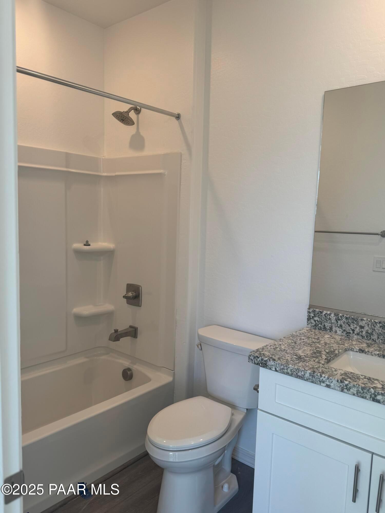 Modern master bathroom featuring walk-in shower, deep soaking tub, granite vanity, and large mirror in Davidson Homes The Summit A, Prescott, Arizona