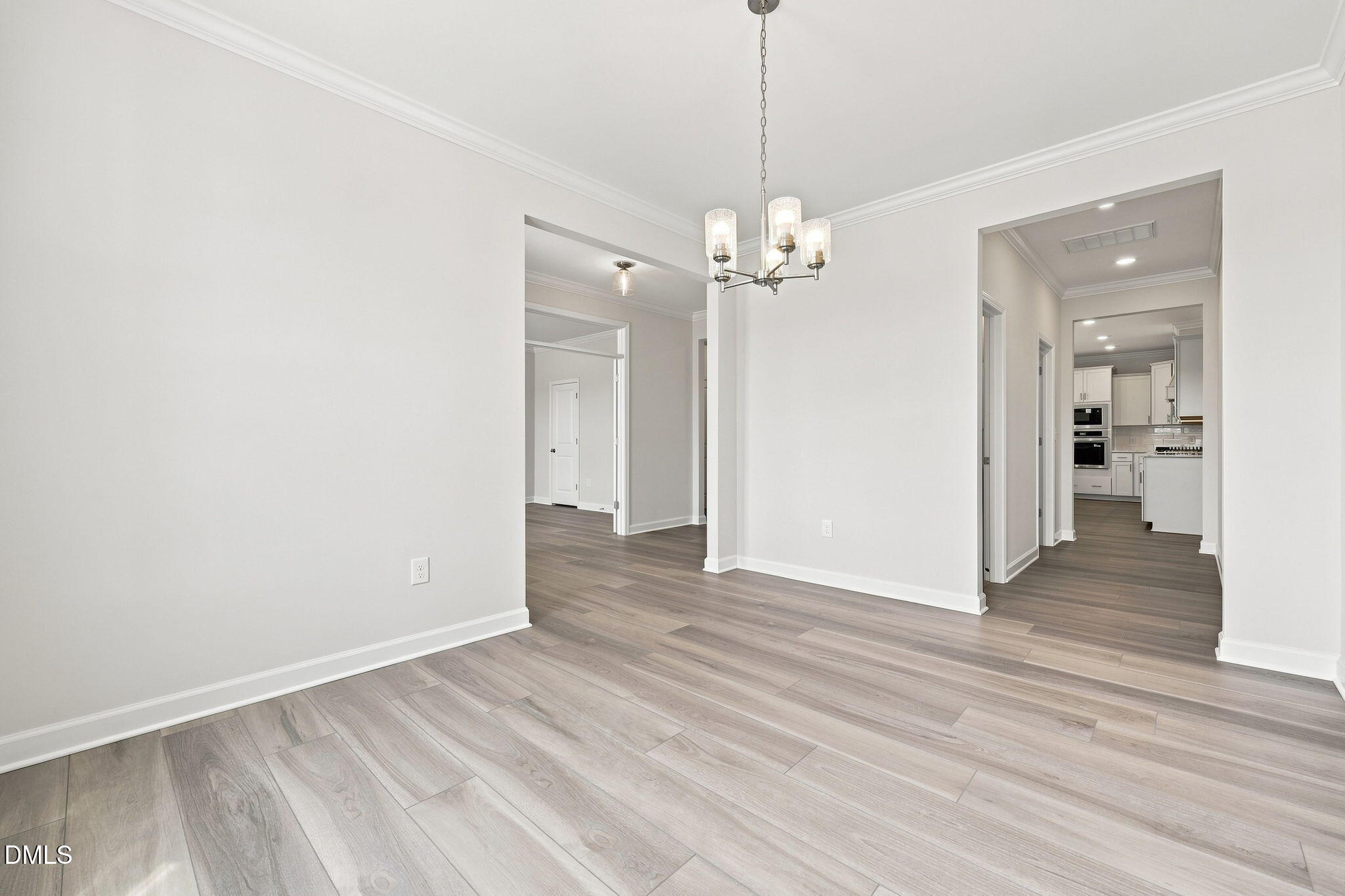 Bright open-concept dining area with chandelier in The Magnolia B floor plan at Retreat at North Main, Lillington, NC.