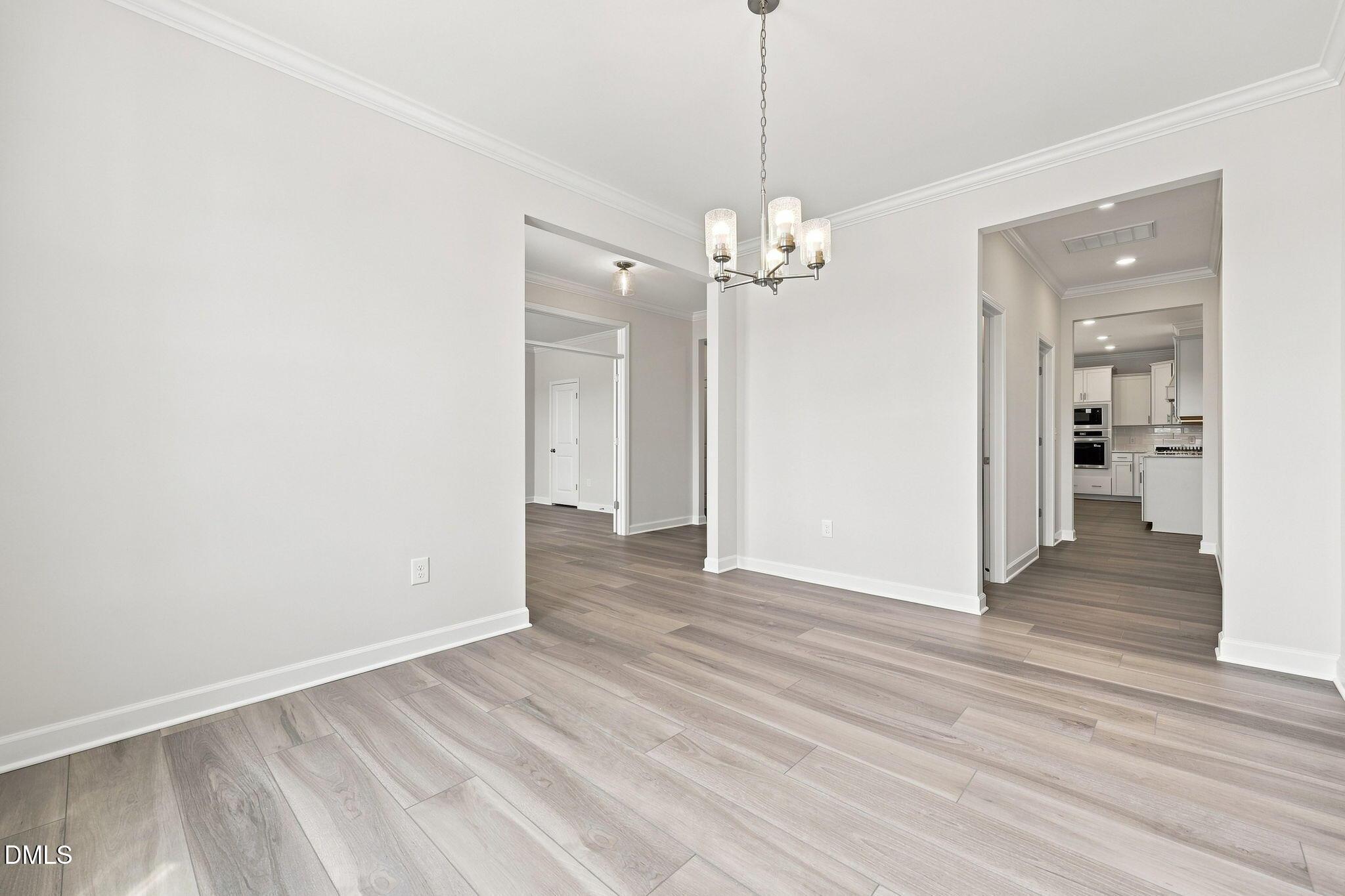 Bright open-concept dining area with chandelier in The Magnolia B floor plan at Retreat at North Main, Lillington, NC.