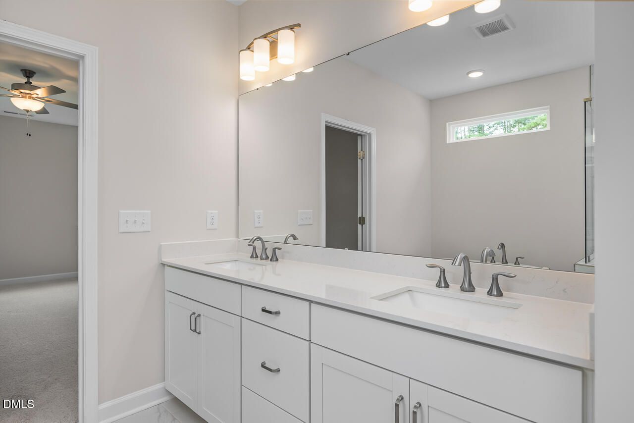 Modern bathroom with double vanity and large mirror in The Hickory II C floor plan at Montrose, Aberdeen, North Carolina.