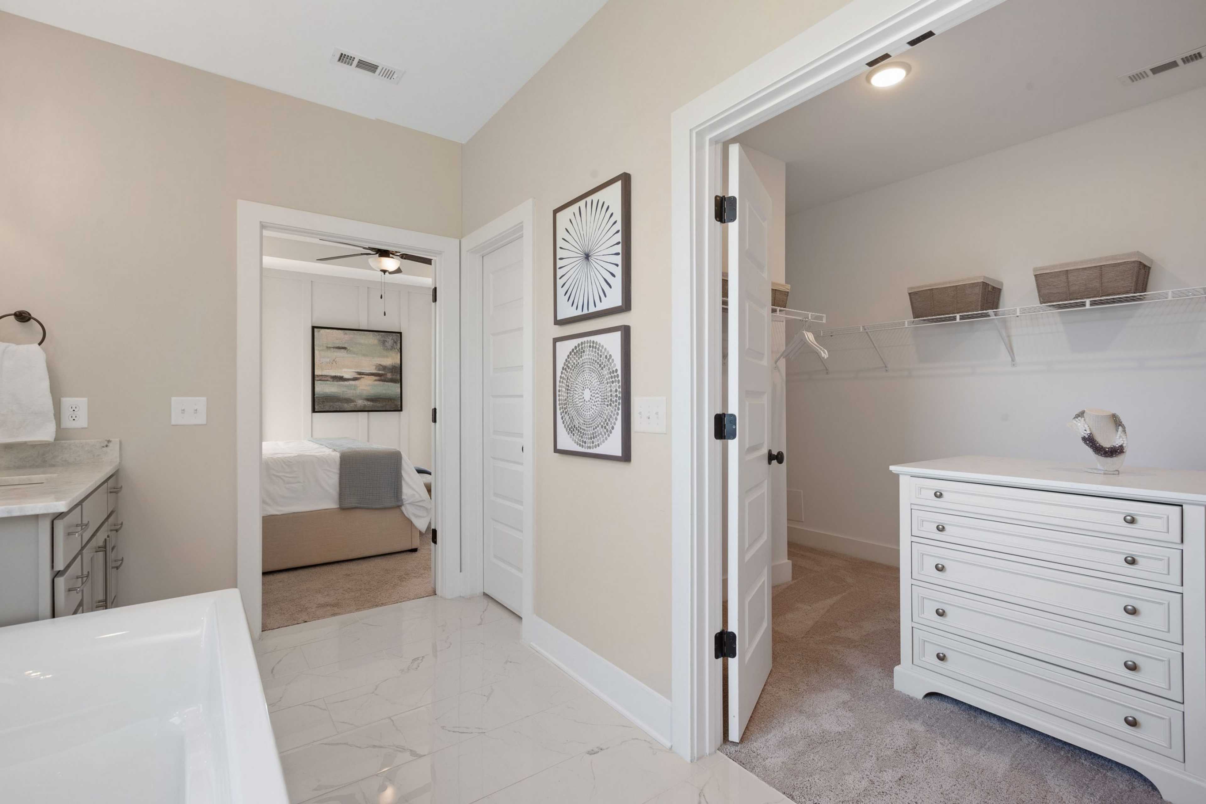 Spacious master bathroom and walk-in closet at Rivers Edge in Murfreesboro TN with freestanding tub, vanity, and custom shelving
