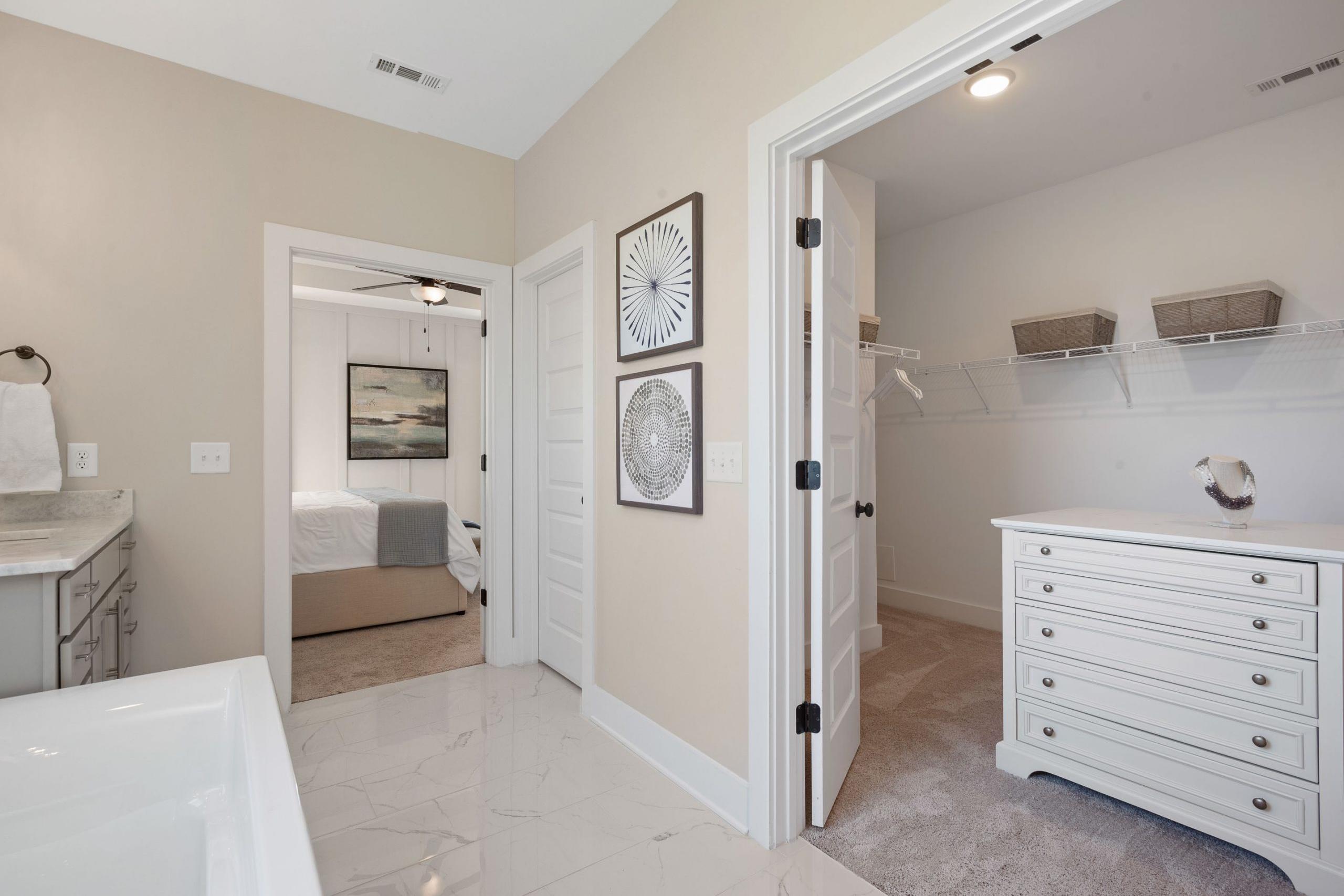 Spacious master bathroom and walk-in closet at Rivers Edge in Murfreesboro TN with freestanding tub, vanity, and custom shelving