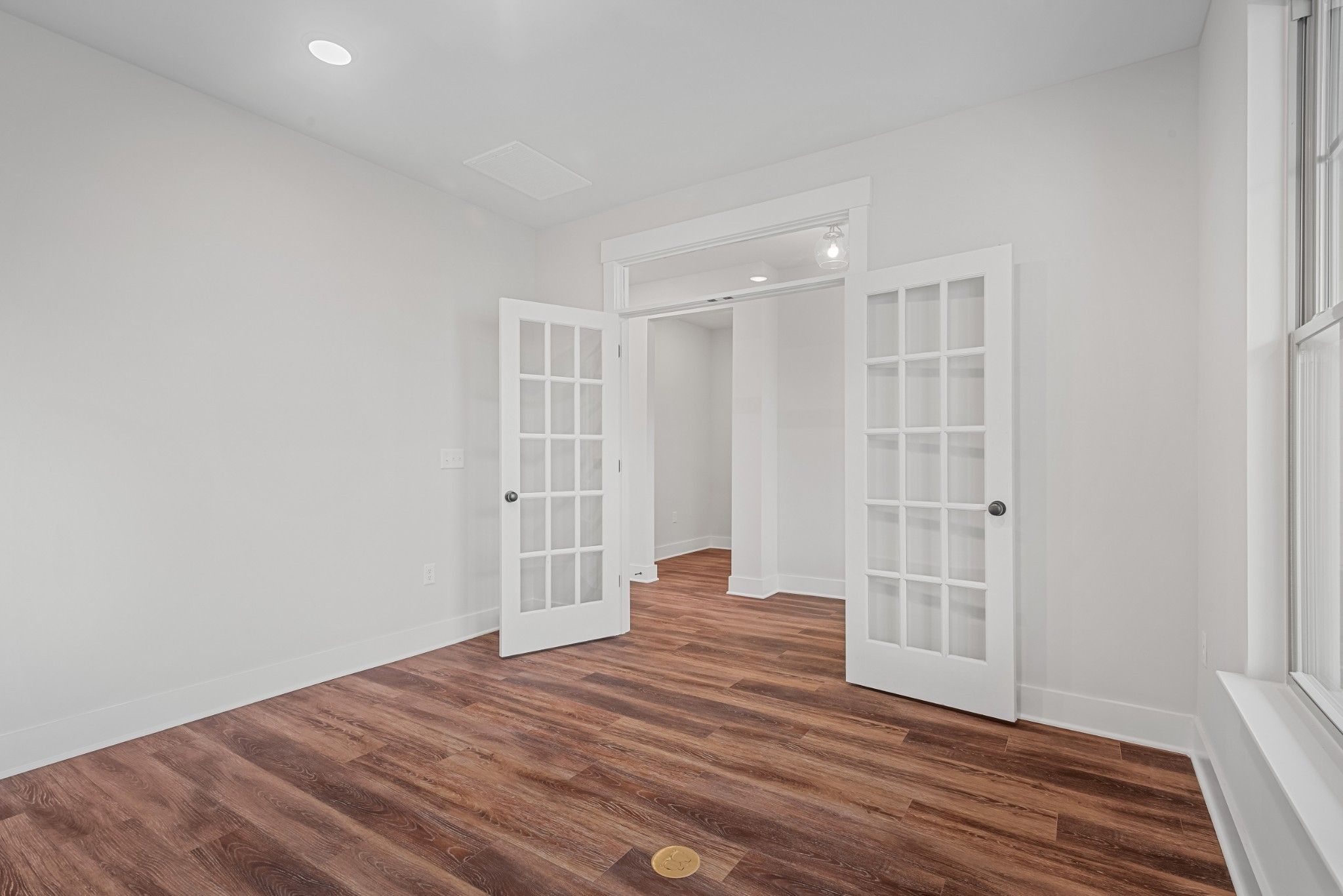 Elegant white French doors open to bright hallway in room with hardwood floors, Davidson Homes The Ash A, Calista Farms TN
