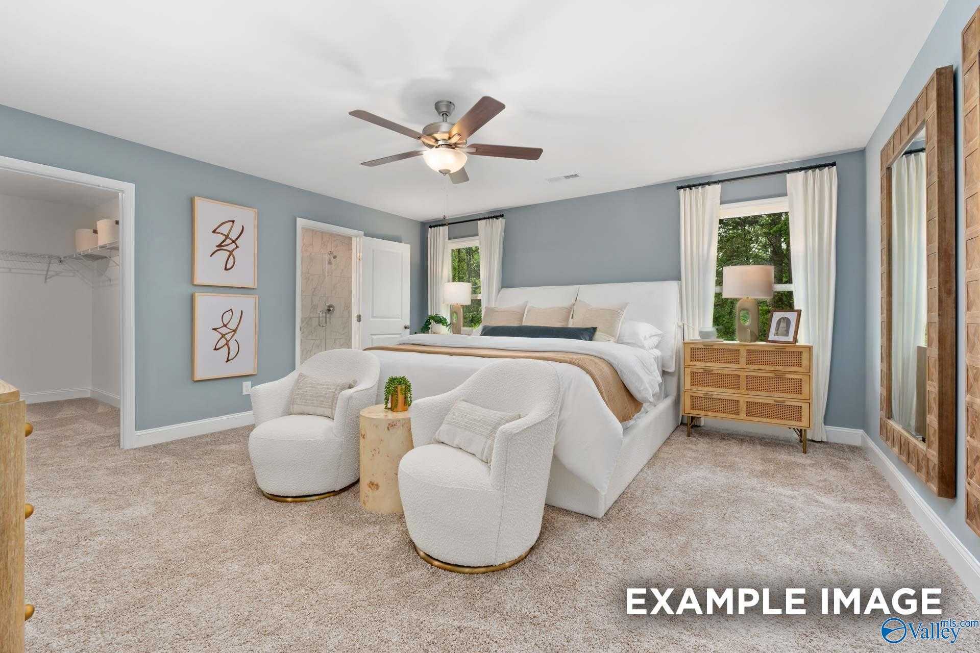 Serene master bedroom with king bed, ceiling fan, accent chairs, and walk-in closet in Davidson Homes The Camden B, Huntsville, Alabama