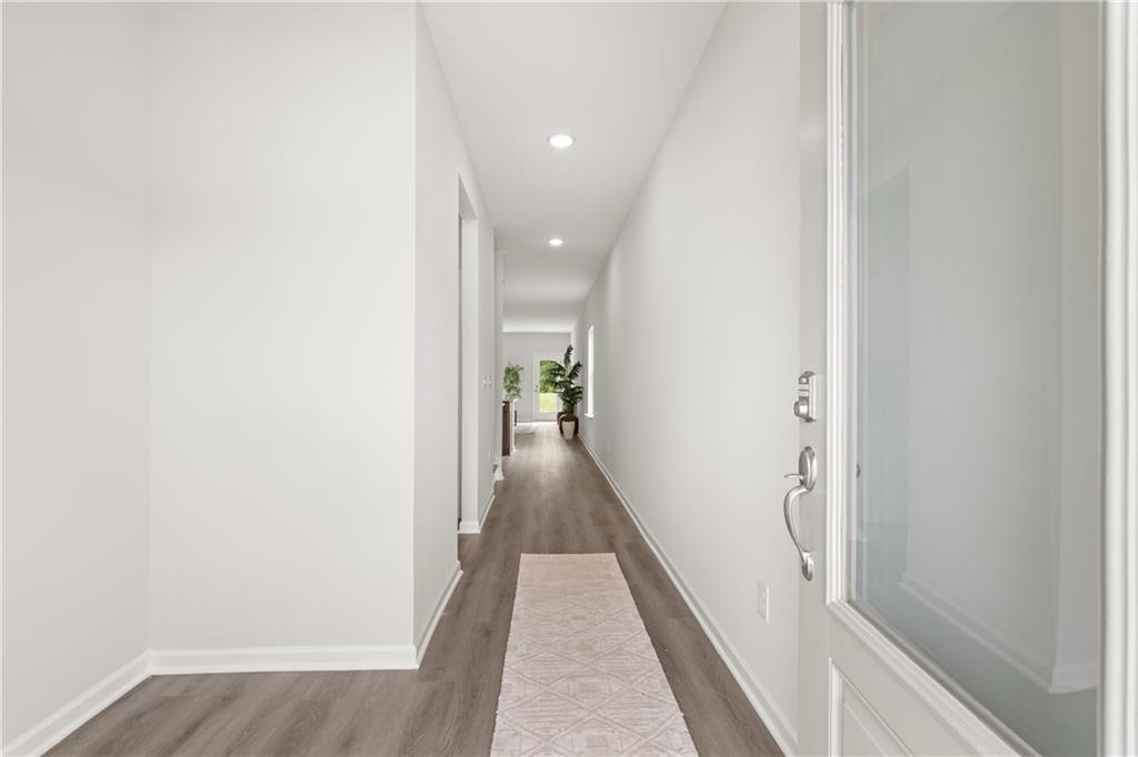 Bright, open foyer and hallway with modern wood-style flooring in The Sinclair B floor plan at Cedar Farms, Winder, GA.