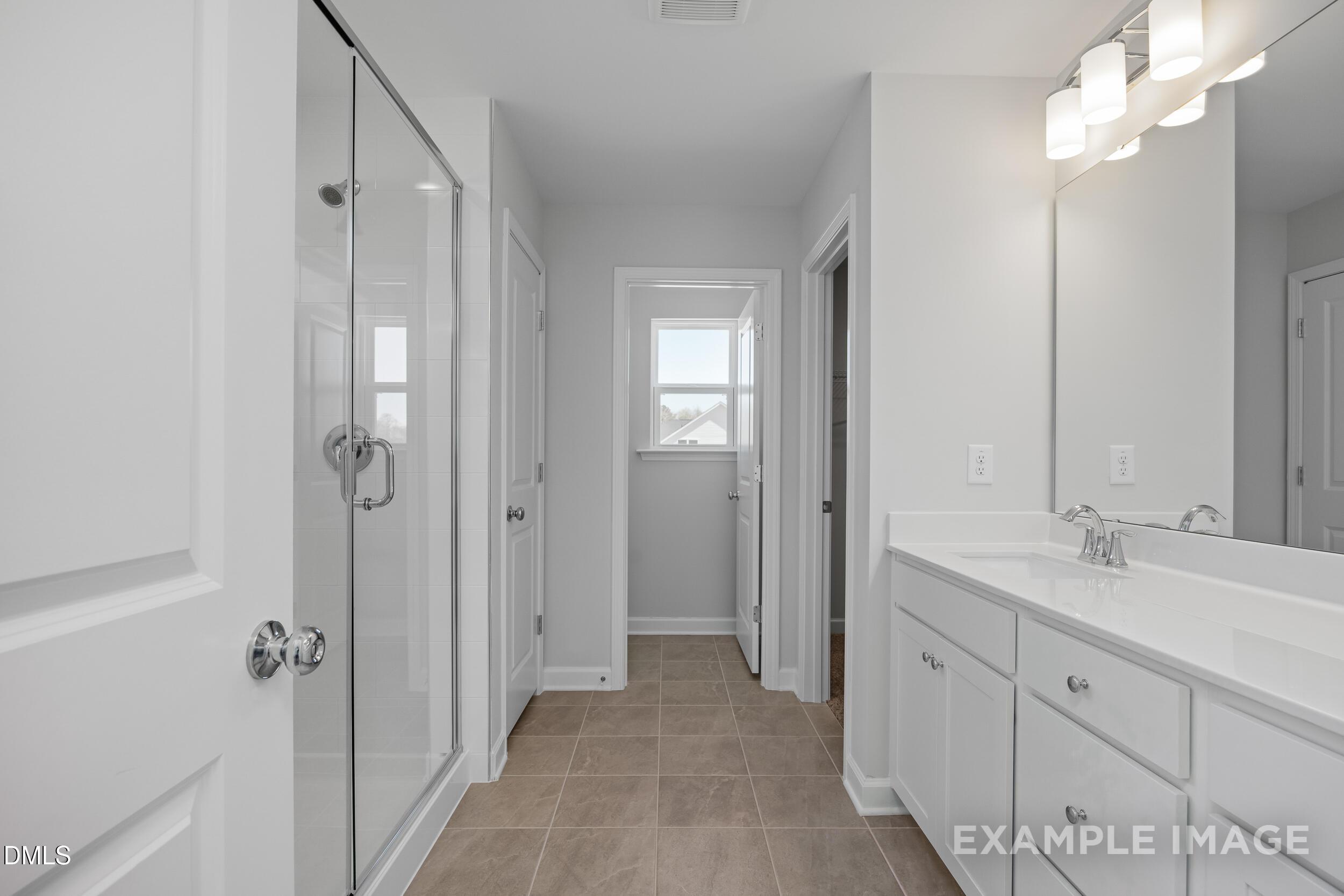 Modern bathroom with glass shower and white vanity in The Gavin A floor plan at Gregory Village, Lillington, NC.
