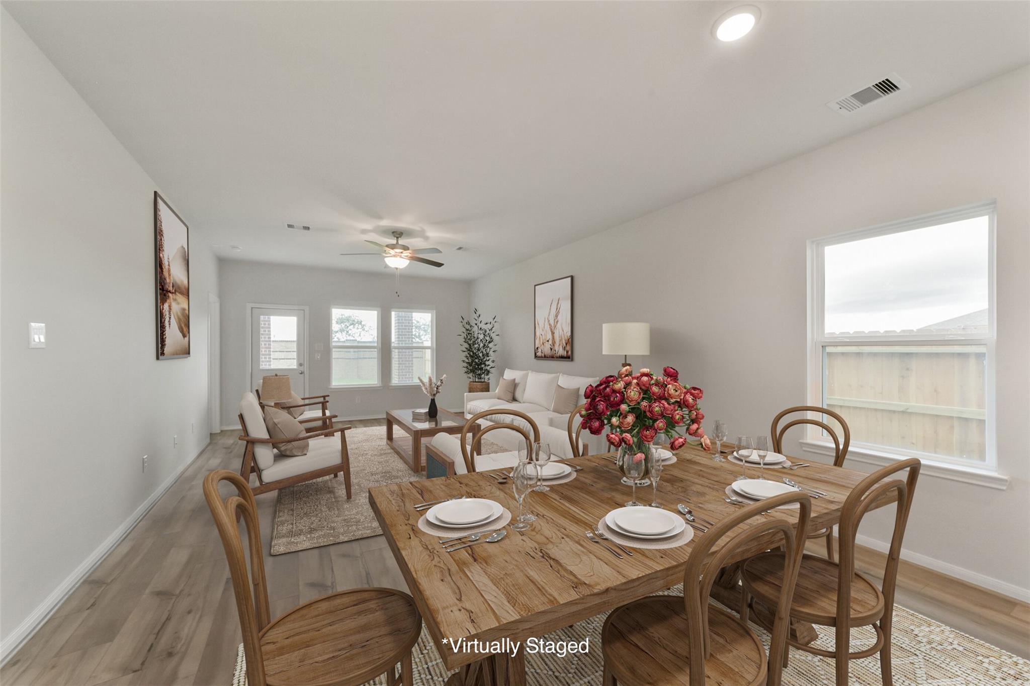 Elegant open dining and living area with rustic wooden table, set for dinner, and cozy seating in The San Marcos E home, Beasley, Texas