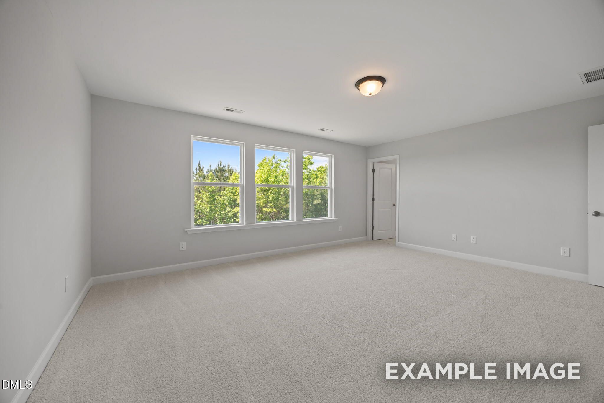 Bright bedroom with carpet and three windows overlooking trees in Davidson Homes' The Beech, Wendell Ridge, North Carolina