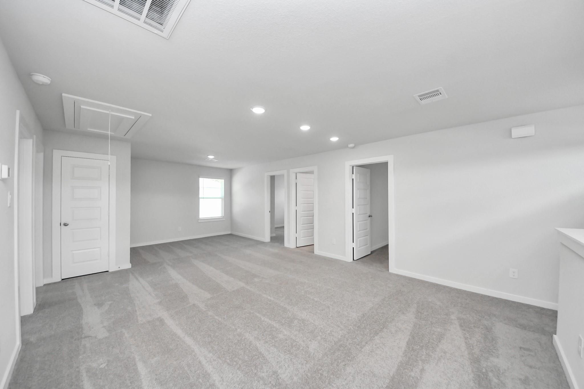 Spacious carpeted game room in The Brazos F floor plan by Davidson Homes at Liberty Estates in Cleveland, Texas.