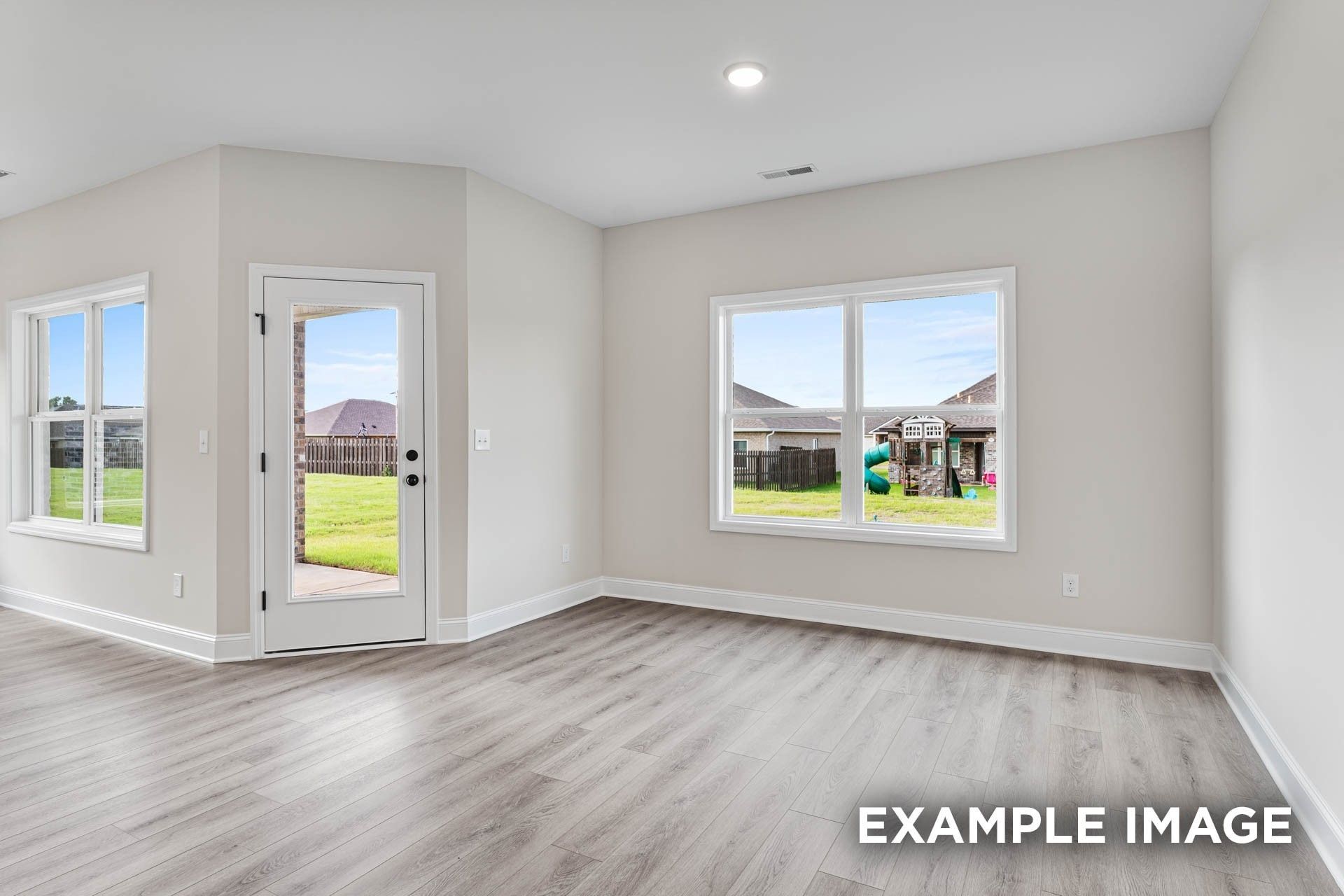 Bright, open-concept living area with wood-style flooring in The Franklin E floor plan at Bailey Park, Fayetteville, TN.