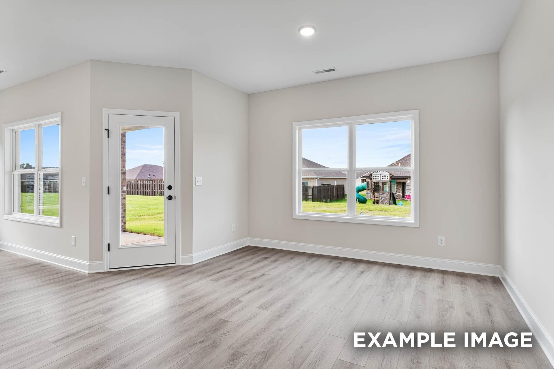Bright, open-concept living area with wood-style flooring in The Franklin E floor plan at Bailey Park, Fayetteville, TN.