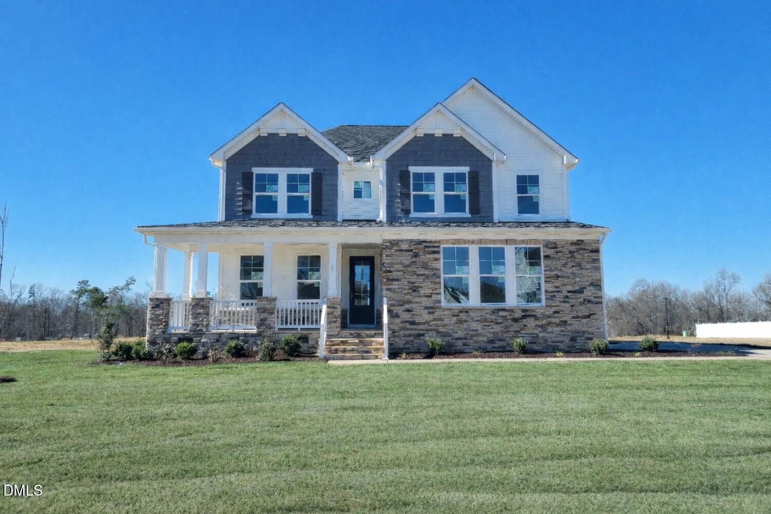 Two-story Willow G home by Davidson Homes: white siding, gray roof, stone accents, covered front porch, large windows on green lawn in Angier, NC