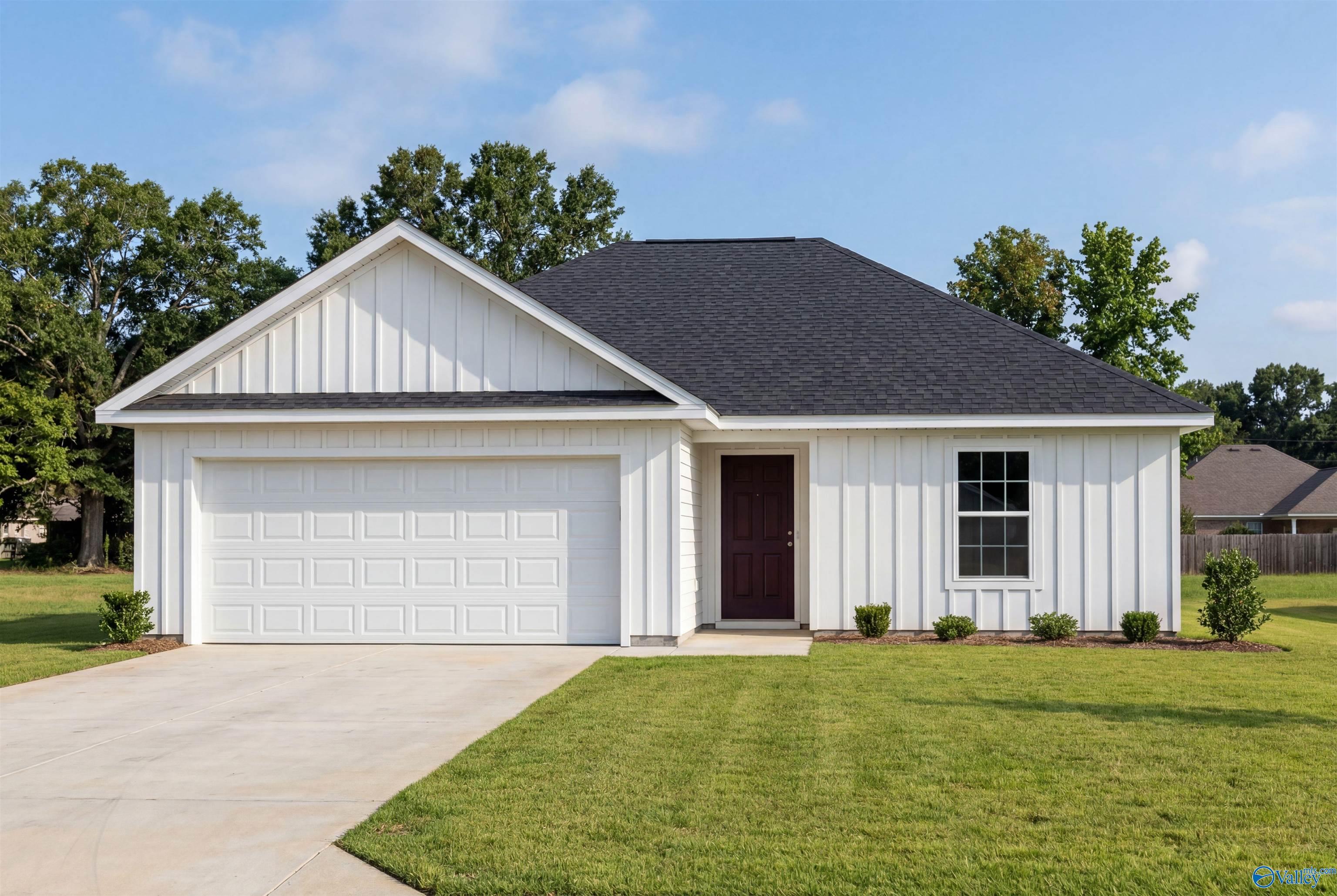 White farmhouse-style exterior of The Butler V, a 1-story, 3-bedroom home with 2-car garage in Chapel Hill, Athens, AL.