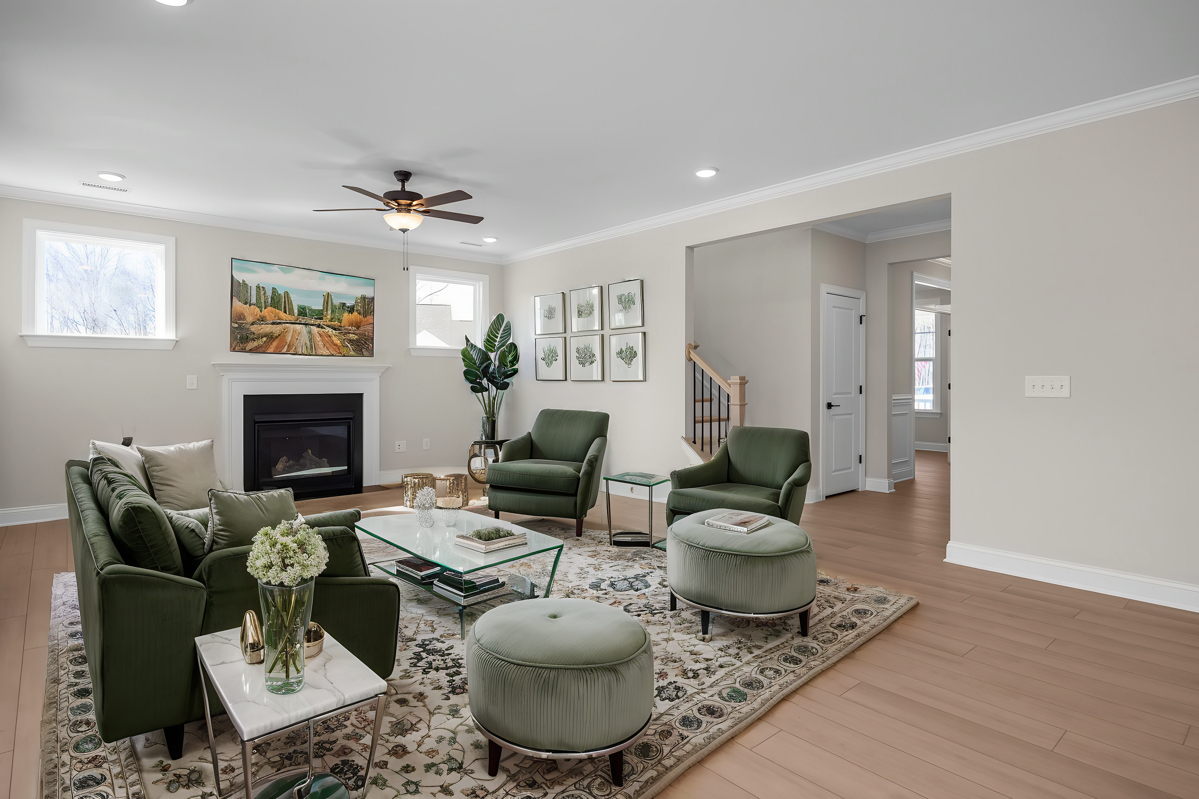 Cozy living room at Enclave at Belmont in Belmont NC with green velvet chairs, fireplace, Tuscan landscape painting, and potted plants