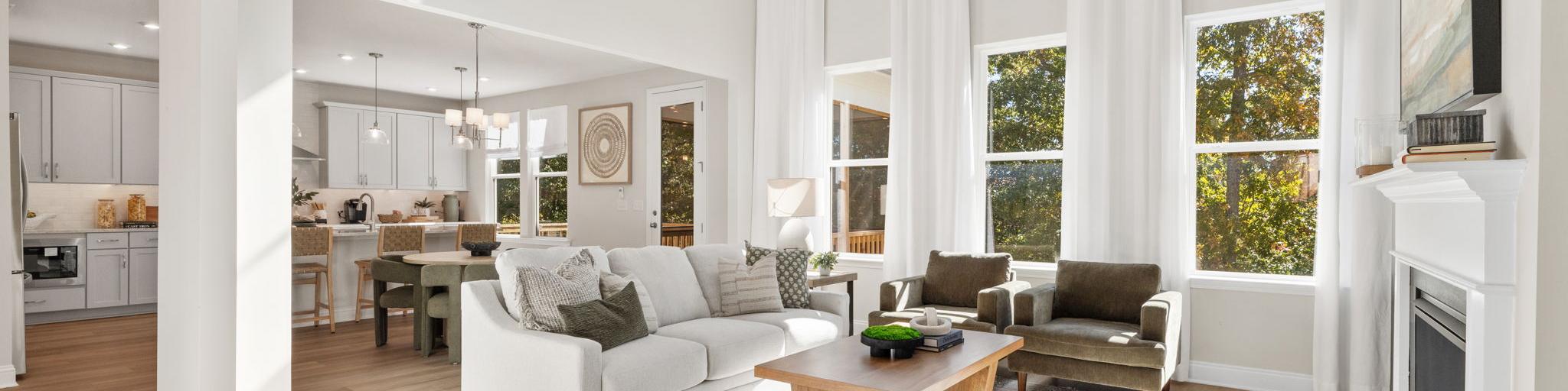 Open-concept kitchen dining living area in Fern Hollow Buford GA with white quartz island hardwood floors pendant lights