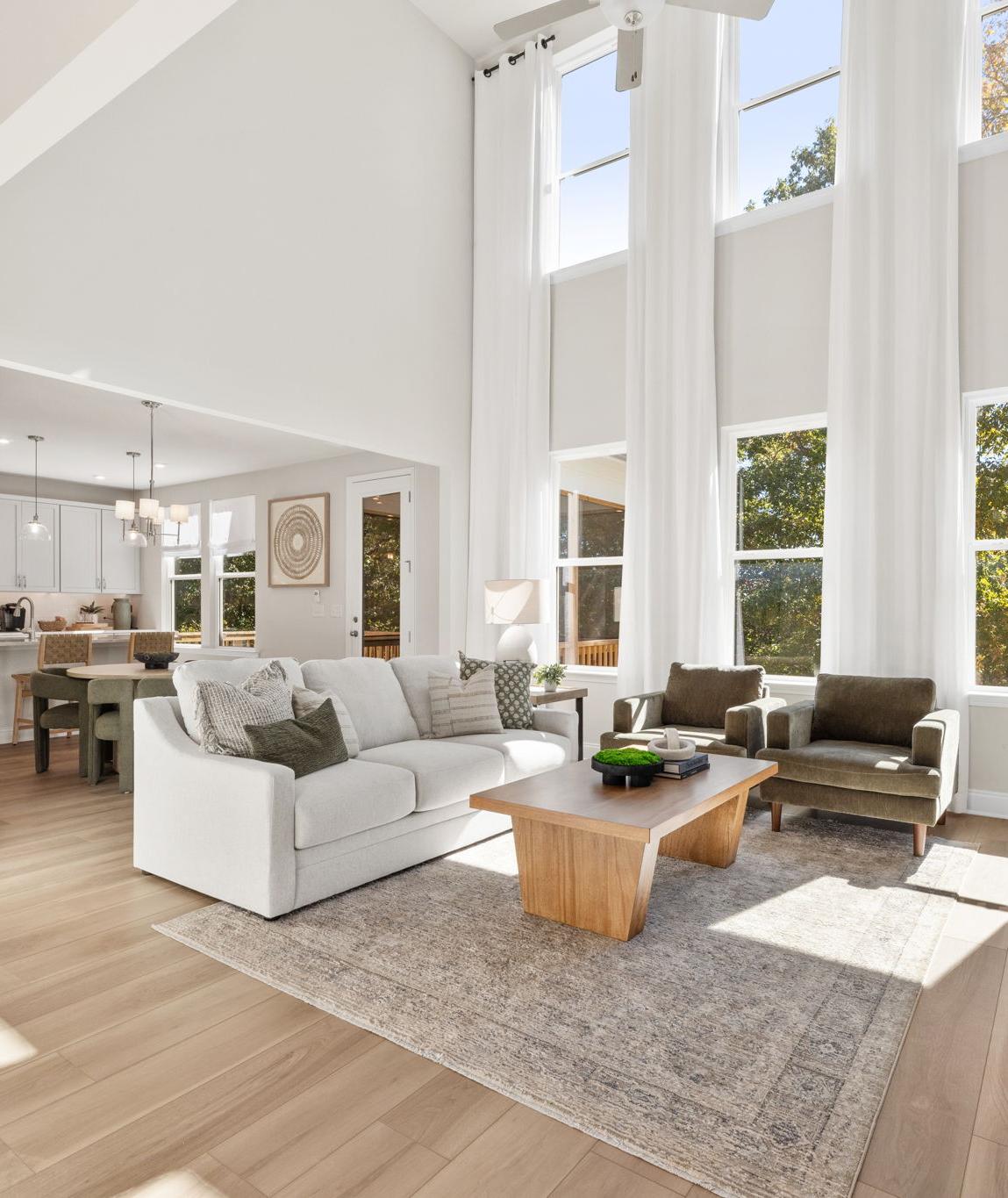 Open-concept kitchen dining living area in Fern Hollow Buford GA with white quartz island hardwood floors pendant lights