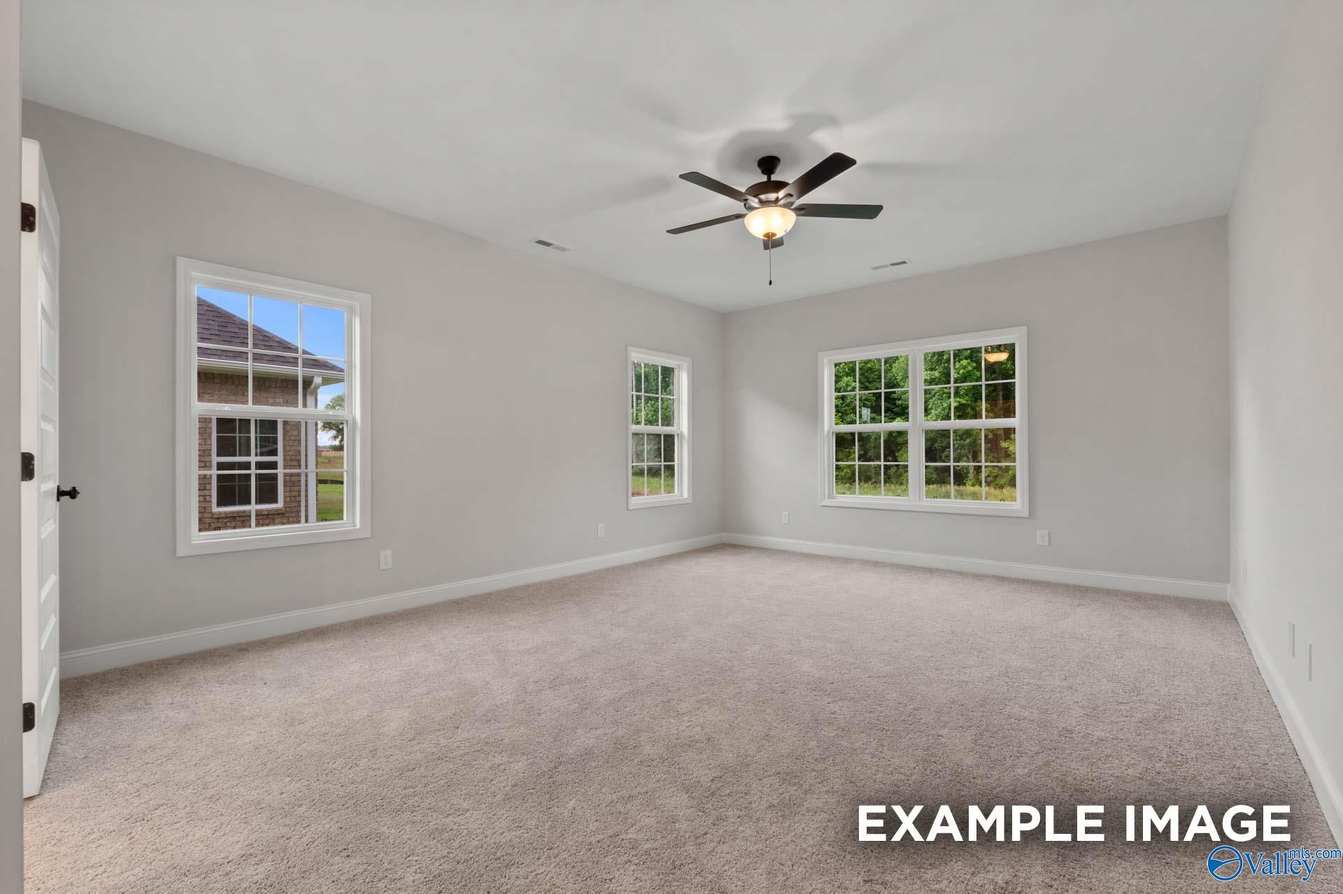 Bright secondary bedroom with large windows, ceiling fan, and neutral carpet in Davidson Homes The Finleigh, Meridianville, AL