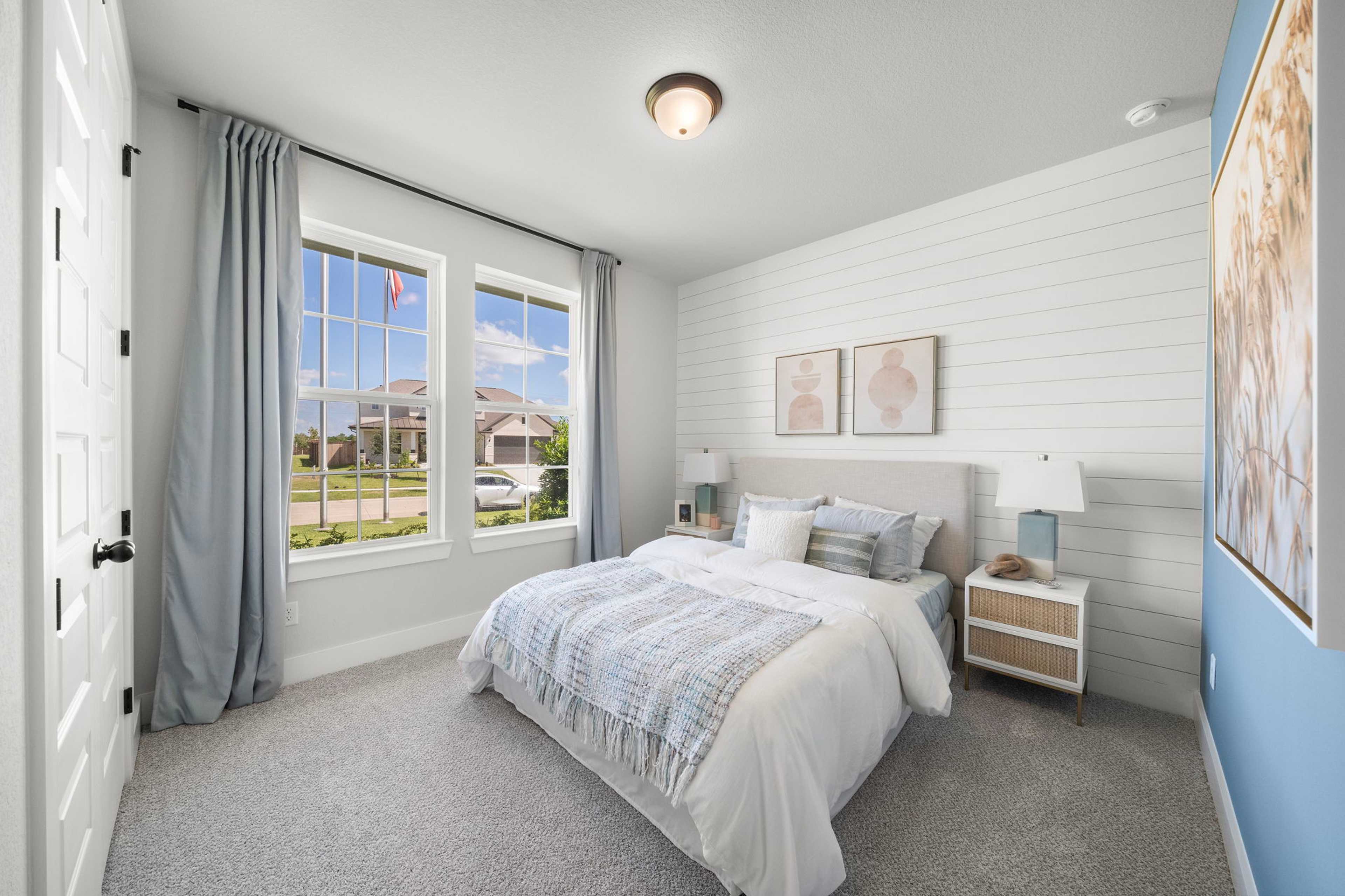 Spacious primary bedroom at Lago Mar in Texas City Texas with shiplap walls king bed large windows and neutral decor