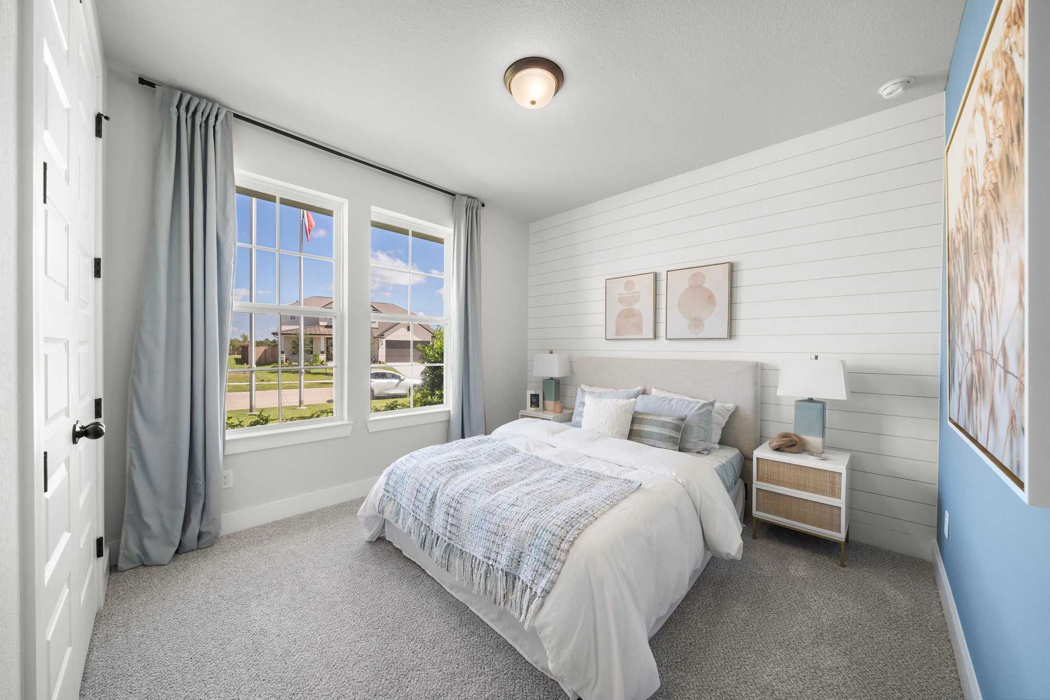 Spacious primary bedroom at Lago Mar in Texas City Texas with shiplap walls king bed large windows and neutral decor