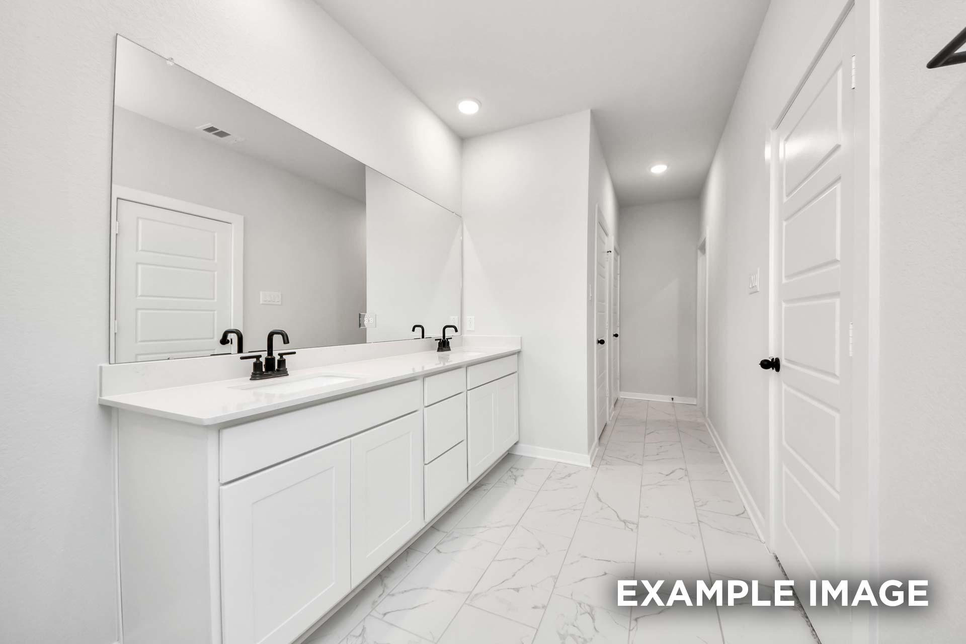 Modern master bathroom in The Sorrento featuring a dual-sink vanity with white cabinets and sleek black fixtures.