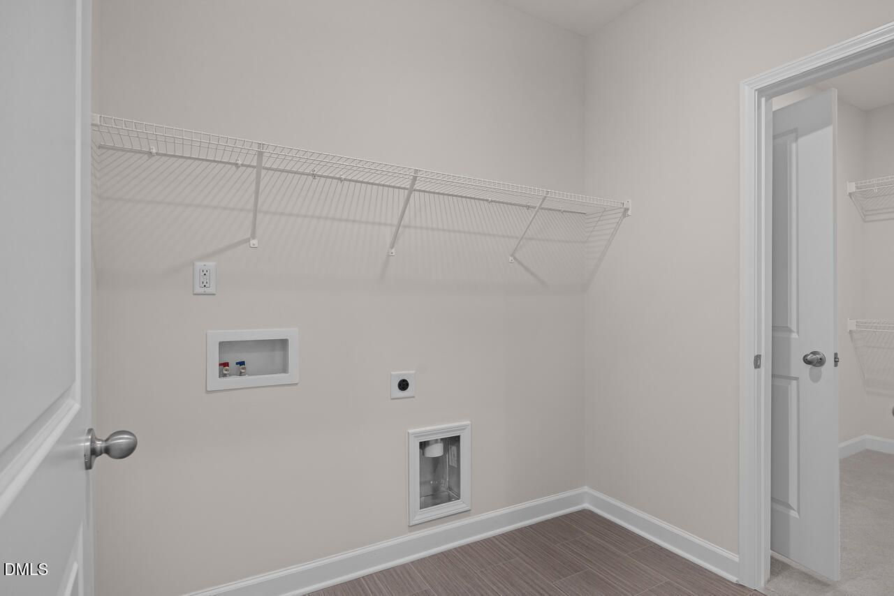 Functional laundry room with wire shelving, washer/dryer hookups in Davidson Homes The Cypress D II, Angier, NC