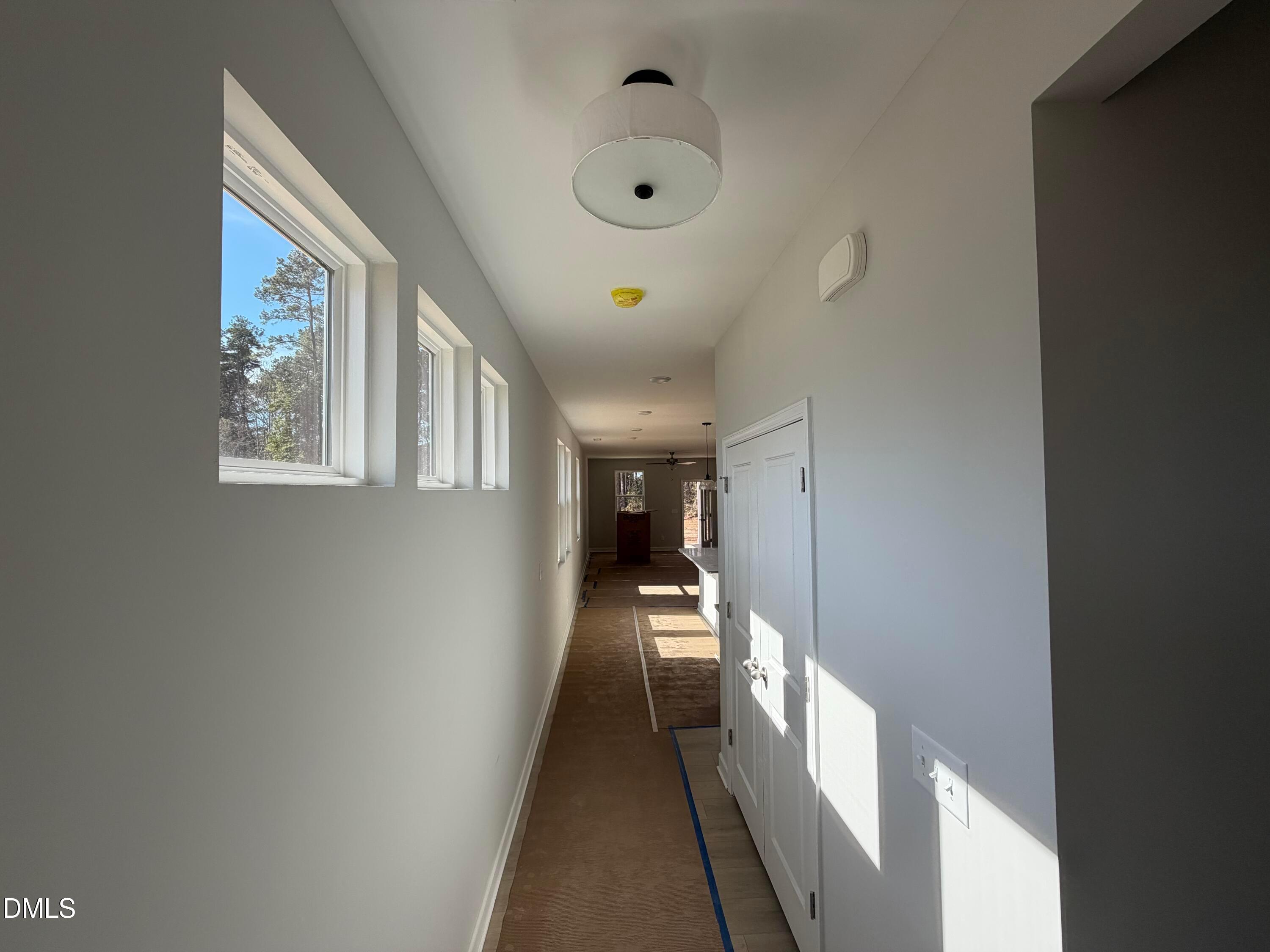 Bright sunlit hallway with clerestory windows and white doors in Davidson Homes The Carter C, Lillington, North Carolina