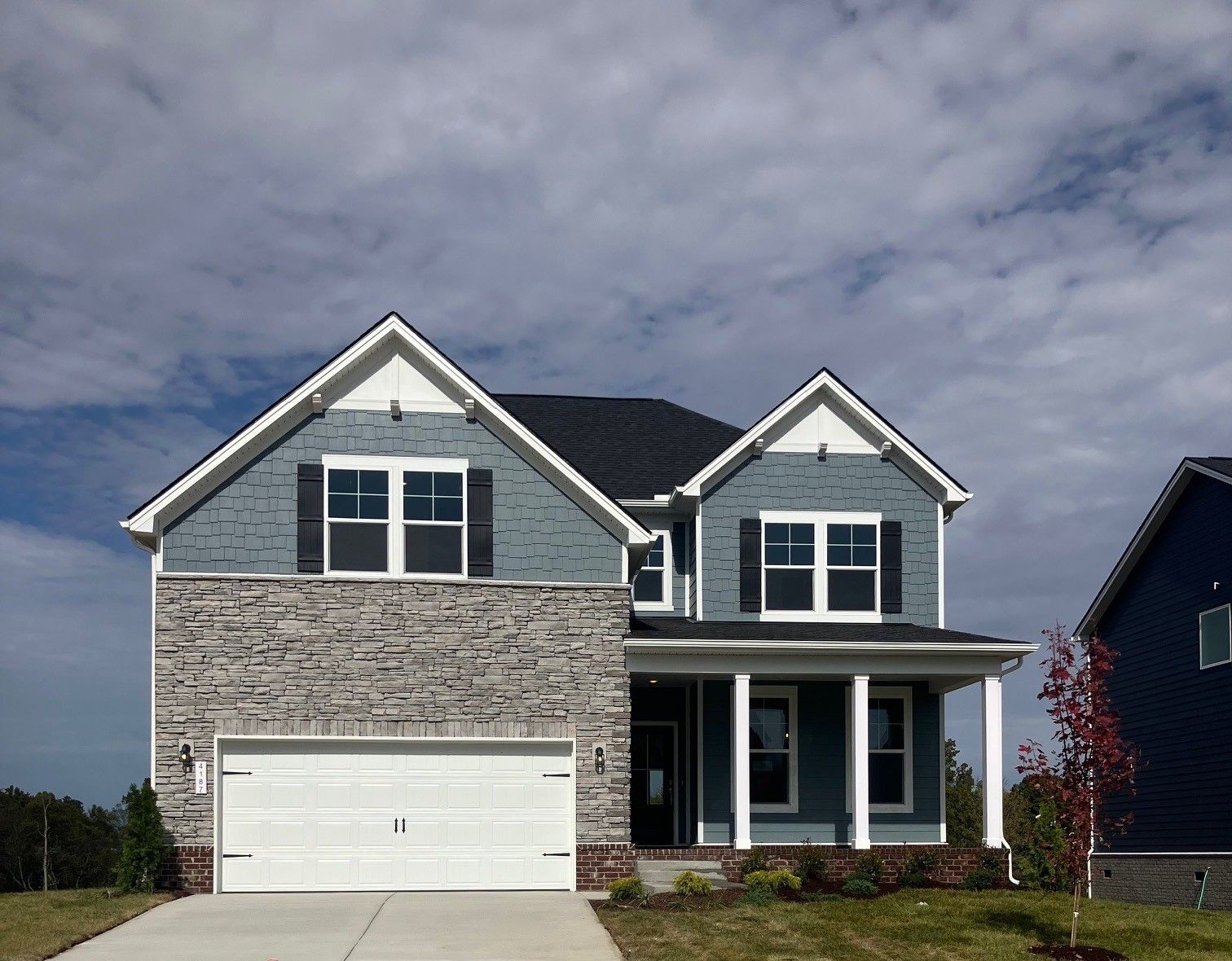 Two-story blue vinyl home with stone facade, 2-car garage, and wraparound porch in Calista Farms, White House, TN - Davidson Homes Willow