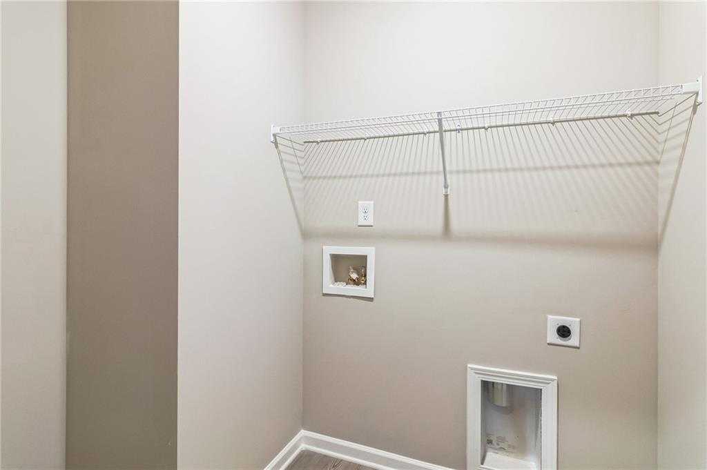 Functional laundry room with wire shelving and washer/dryer hookups in Evermore Homes The Stella, Ivy Glen, Perry, Georgia