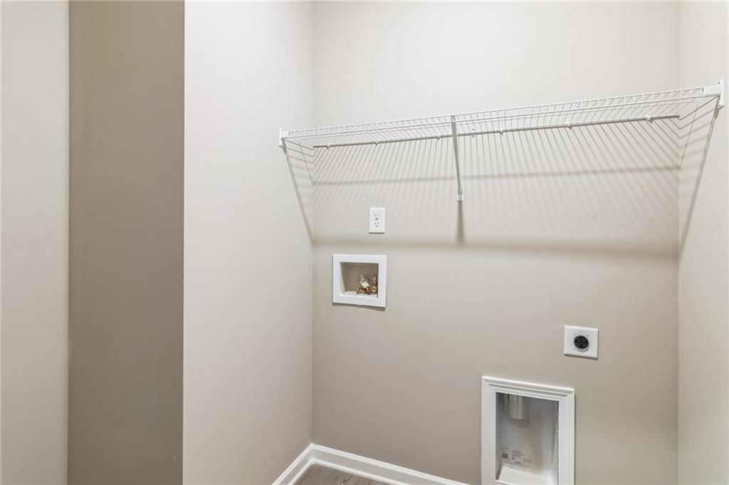 Functional laundry room with wire shelving and washer/dryer hookups in Evermore Homes The Stella, Ivy Glen, Perry, Georgia