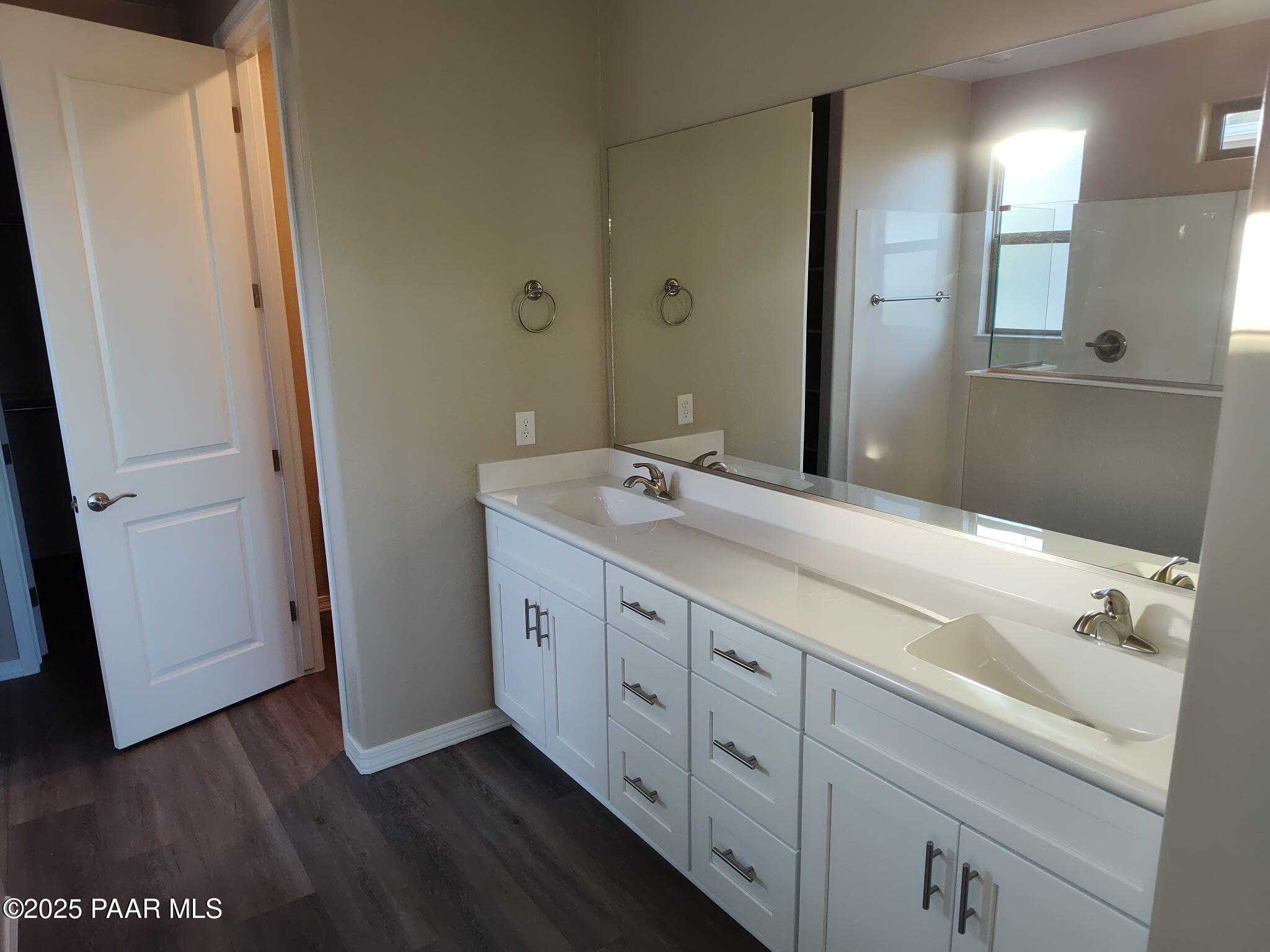 Modern master bathroom with dual sinks, white cabinets, large mirror, and walk-in shower in Davidson Homes The Inspiration A, Prescott Valley