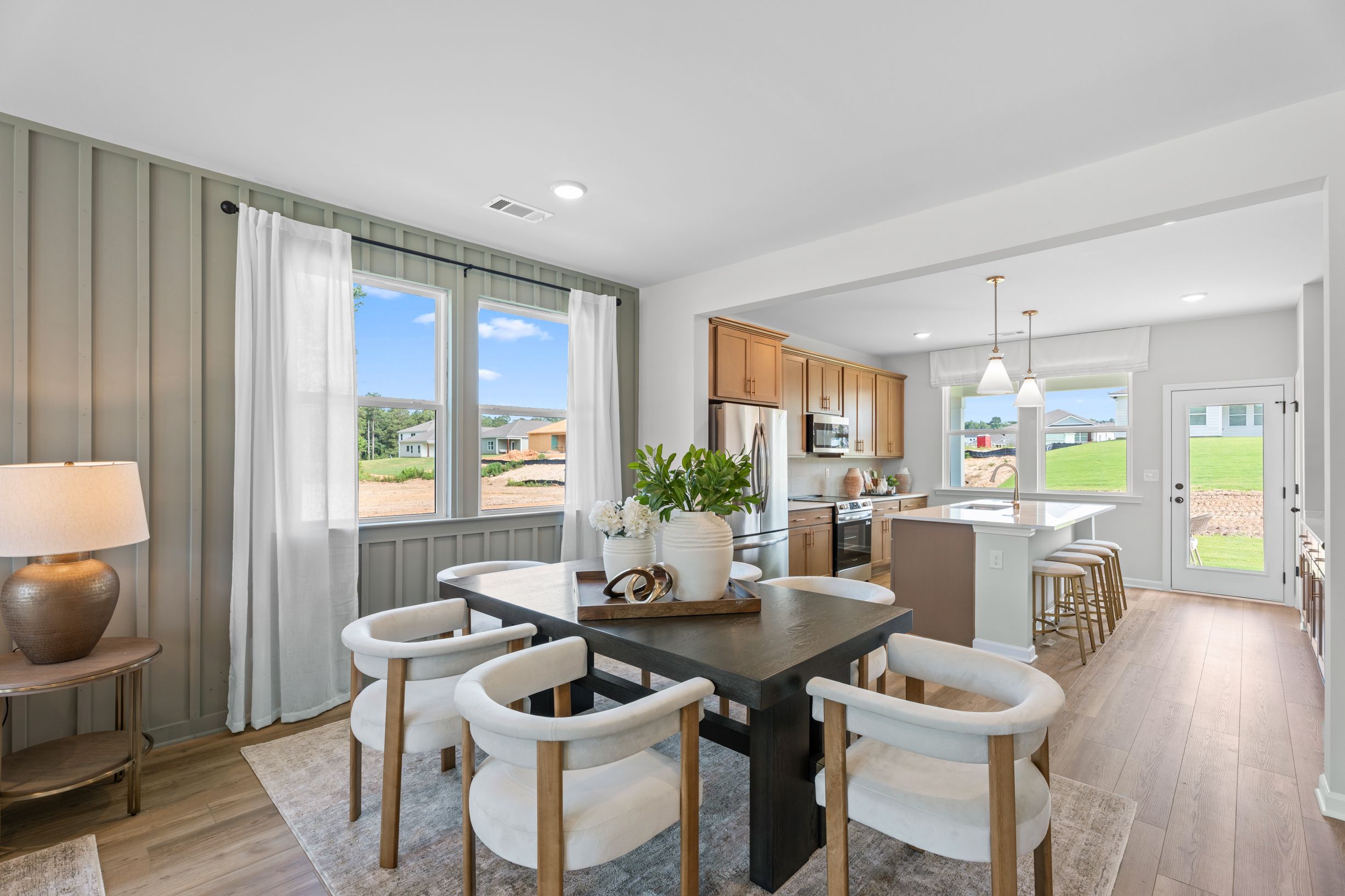 Open-concept dining and kitchen area at Links Crossing in Auburn, Alabama, featuring modern decor and hardwood floors.