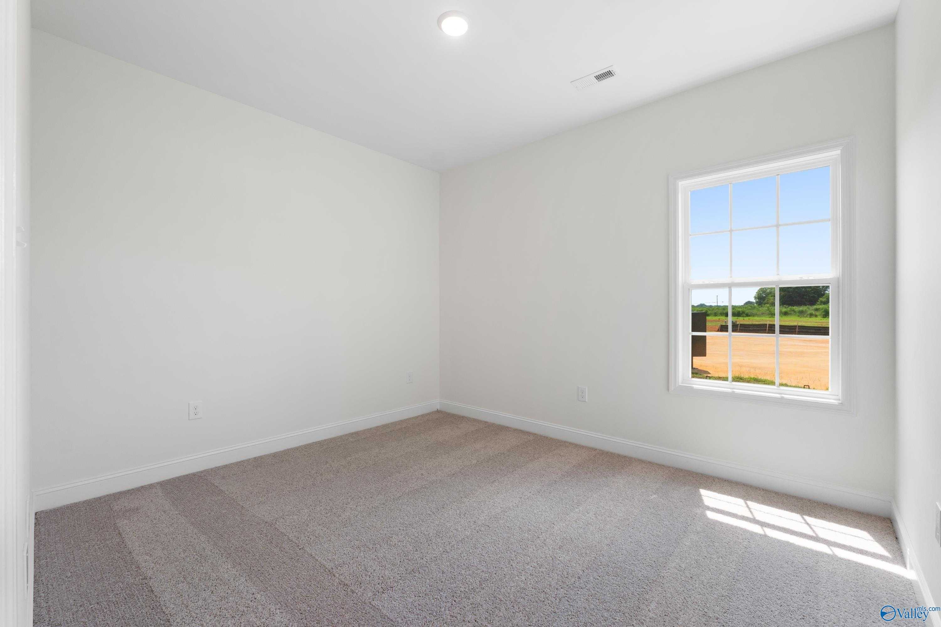Bright secondary bedroom with large window overlooking baseball field in Davidson Homes The Rockford B, Toney, Alabama
