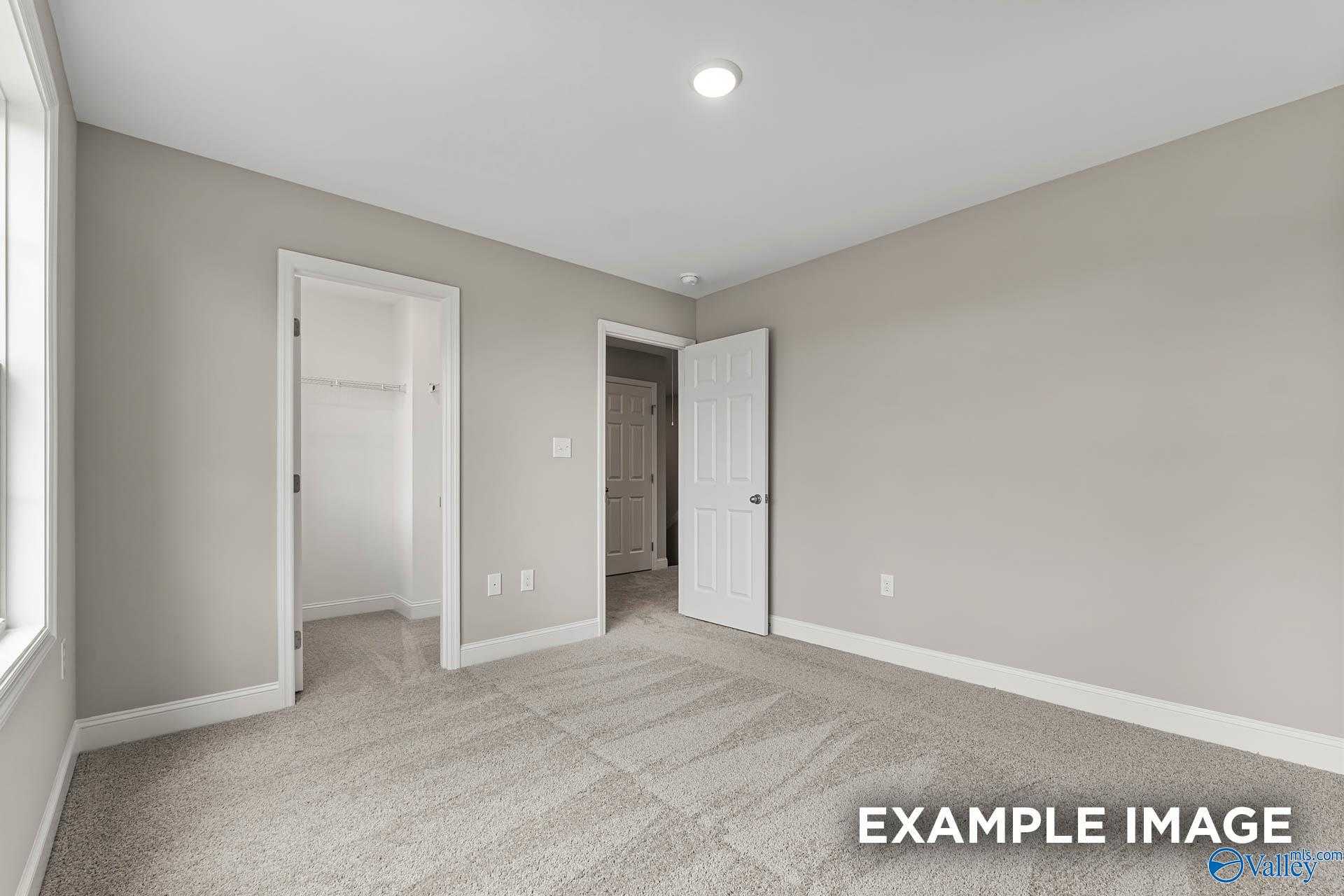 Spacious secondary bedroom with gray walls, walk-in closet, en-suite bath in Davidson Homes Chelsea A, Athens AL