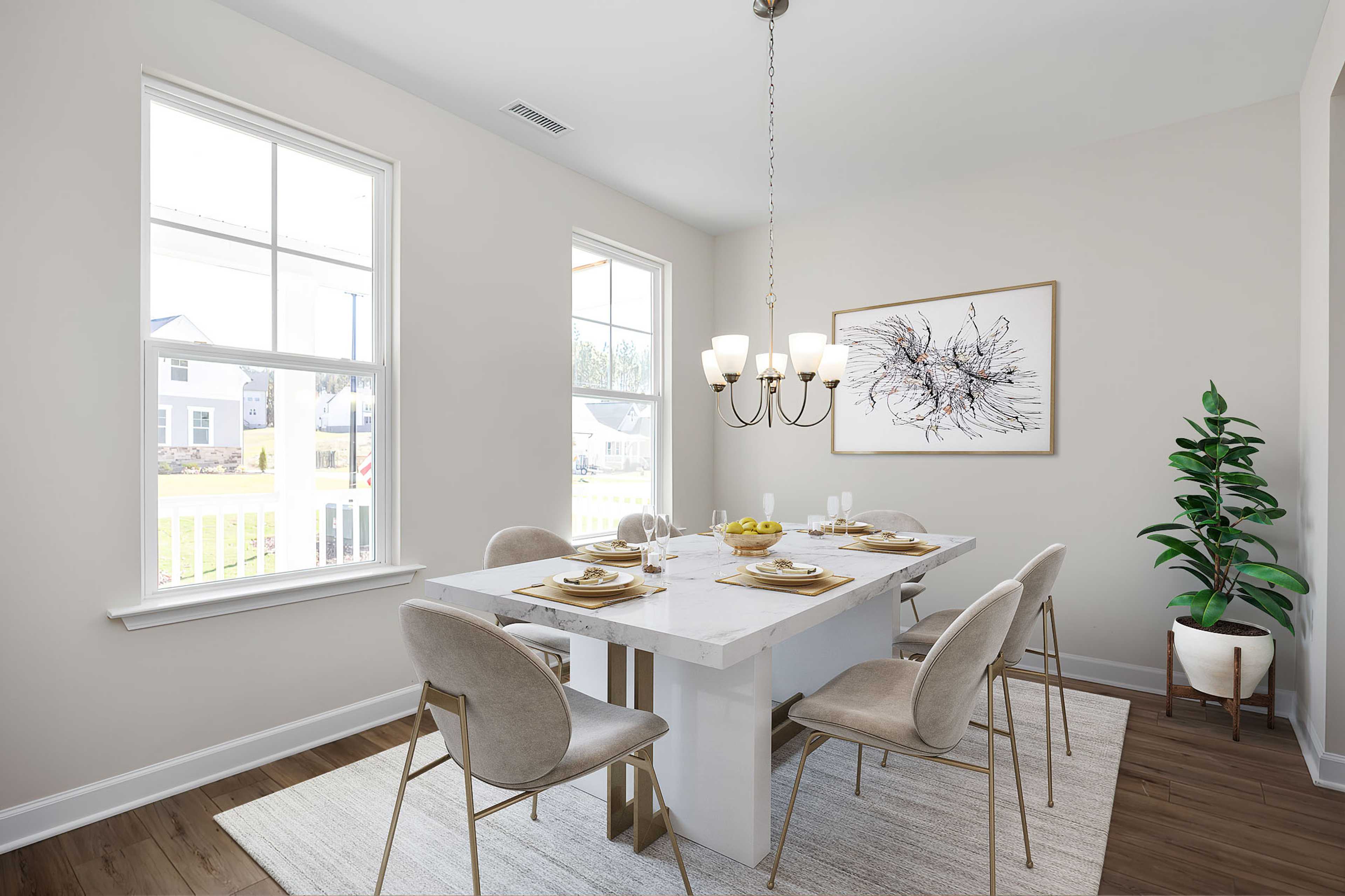 Spacious dining room at Stagecoach Corner in Mebane NC with white table, chandelier, large windows, and abstract art
