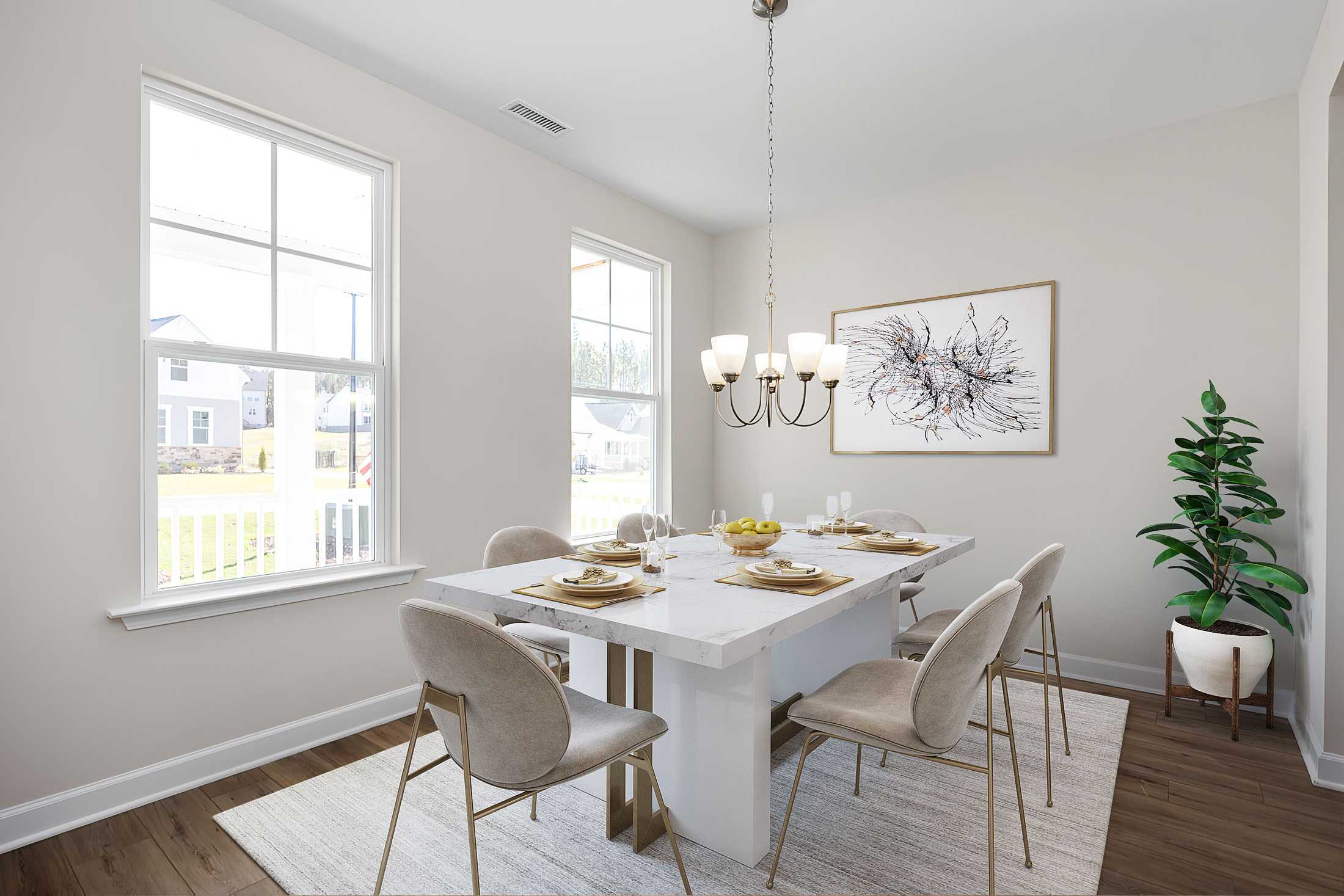Spacious dining room at Stagecoach Corner in Mebane NC with white table, chandelier, large windows, and abstract art