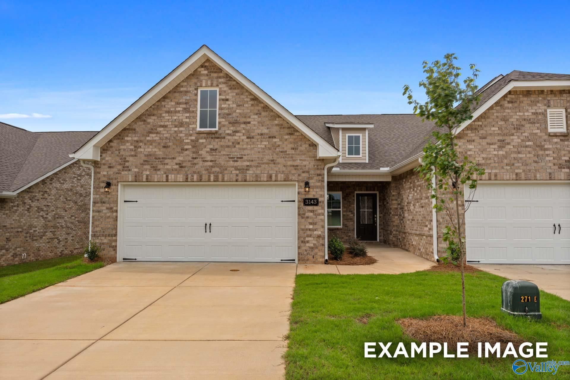 Brick single-story home with 2-car garage, front entry, and driveway in The Retreat at Hollon Meadow, Decatur, Alabama
