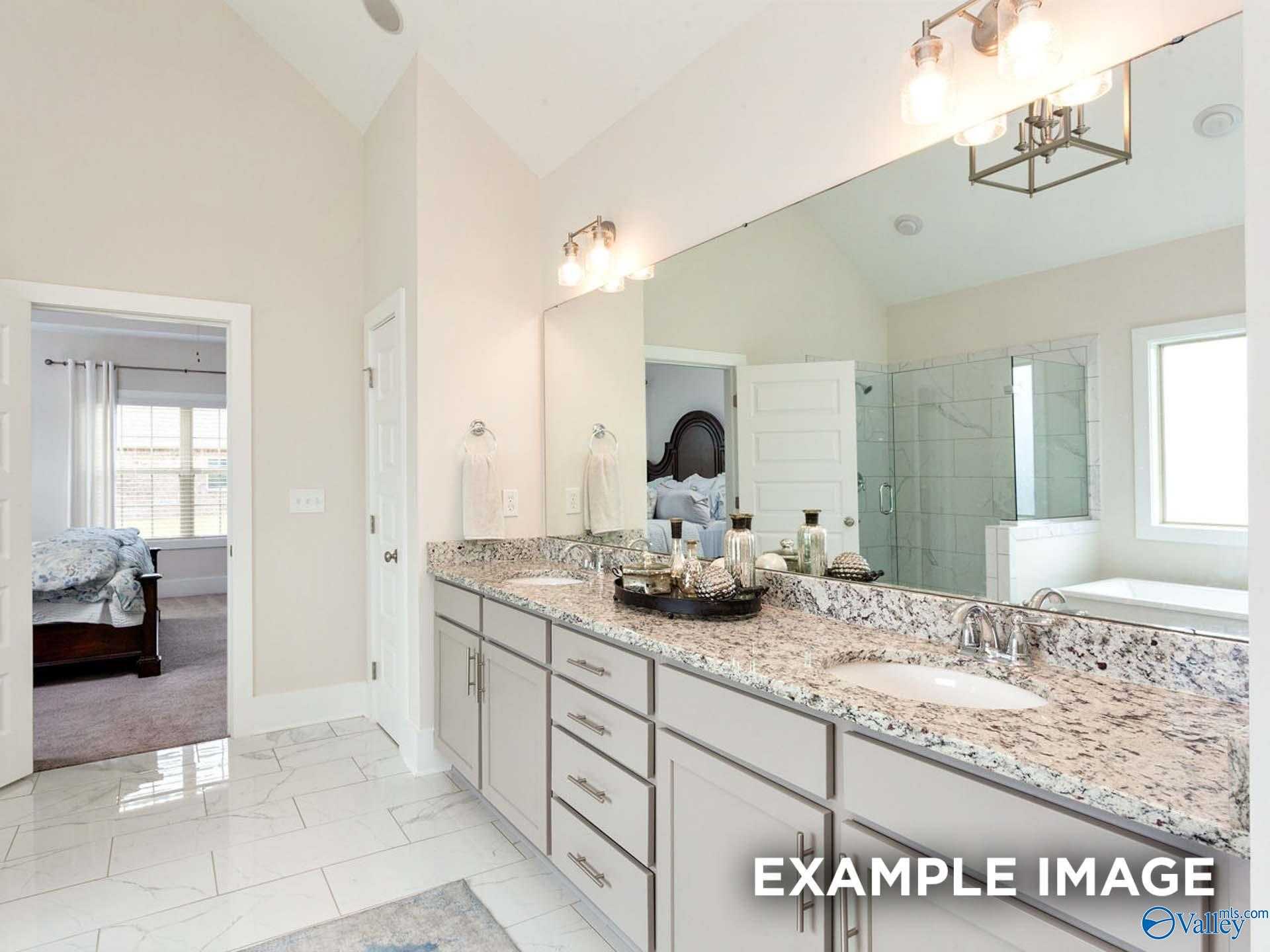 Elegant master bathroom featuring double granite vanity, frameless shower, soaking tub in Davidson Homes The Finleigh, Meridianville, Alabama