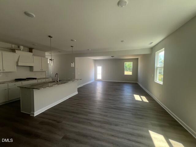 Modern open-concept kitchen with white shaker cabinets, granite island, stainless appliances in Davidson Homes The Adalynn A, Lillington, NC