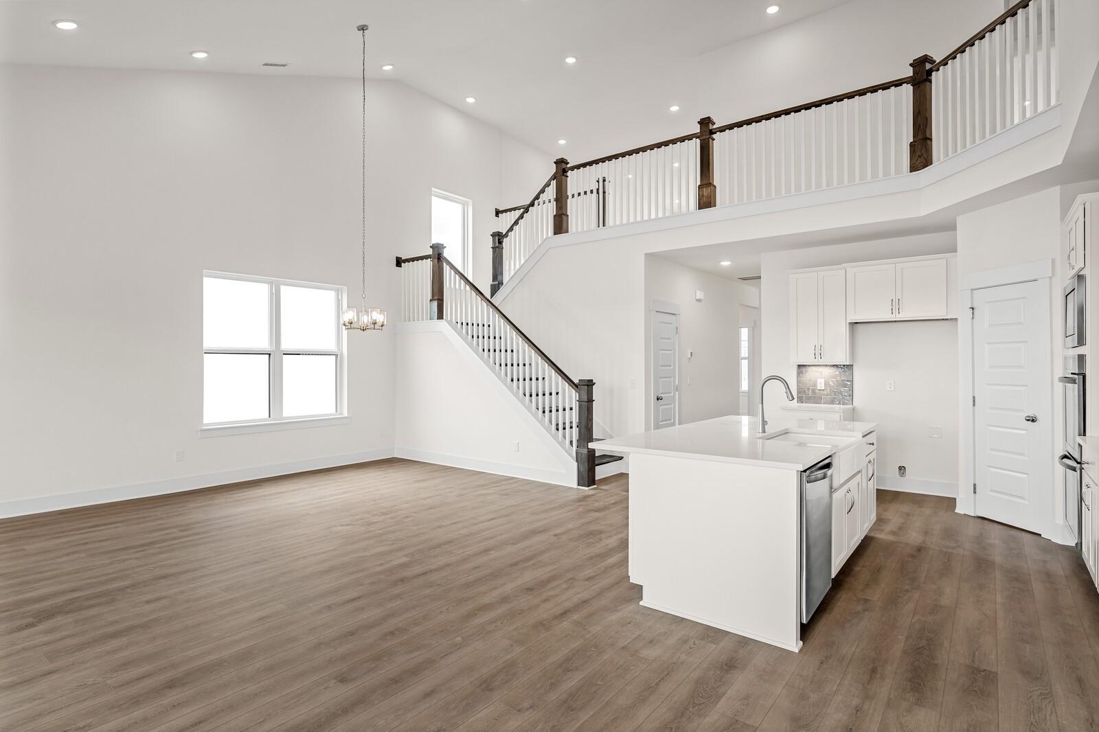 Two-story open floor plan with vaulted ceiling, staircase, and kitchen island in The Ridgeport D at Benders Cove, Mt. Juliet.
